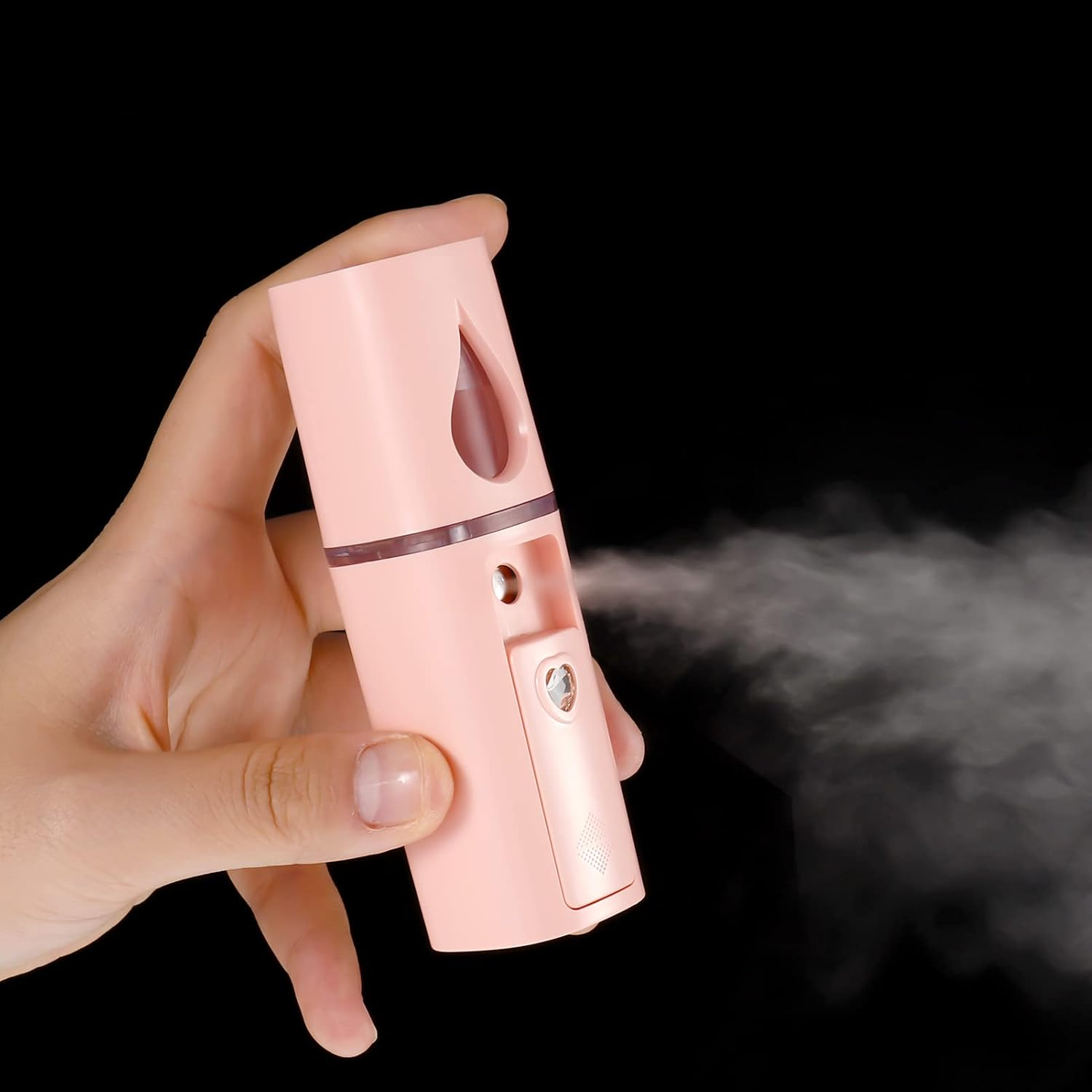 Eine Hand hält einen rosa Sprüher, der Nebel versprüht.