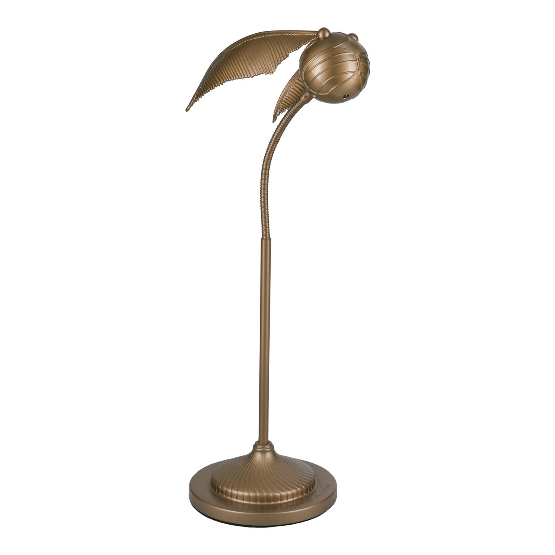 Złota lampa Znicz stoi na okrągłej podstawie.