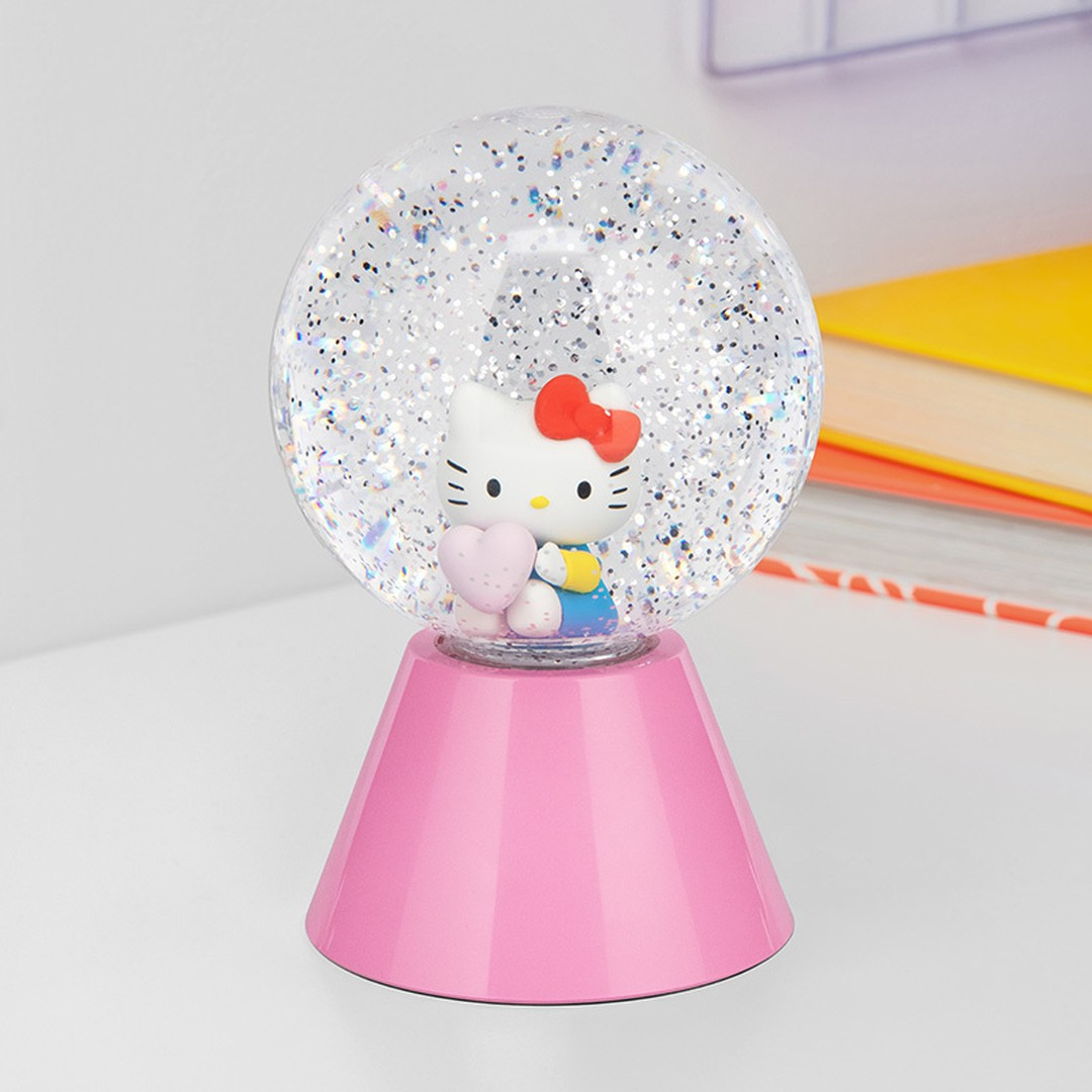 Kula śnieżna Hello Kitty z brokatową wodą i różową podstawą.