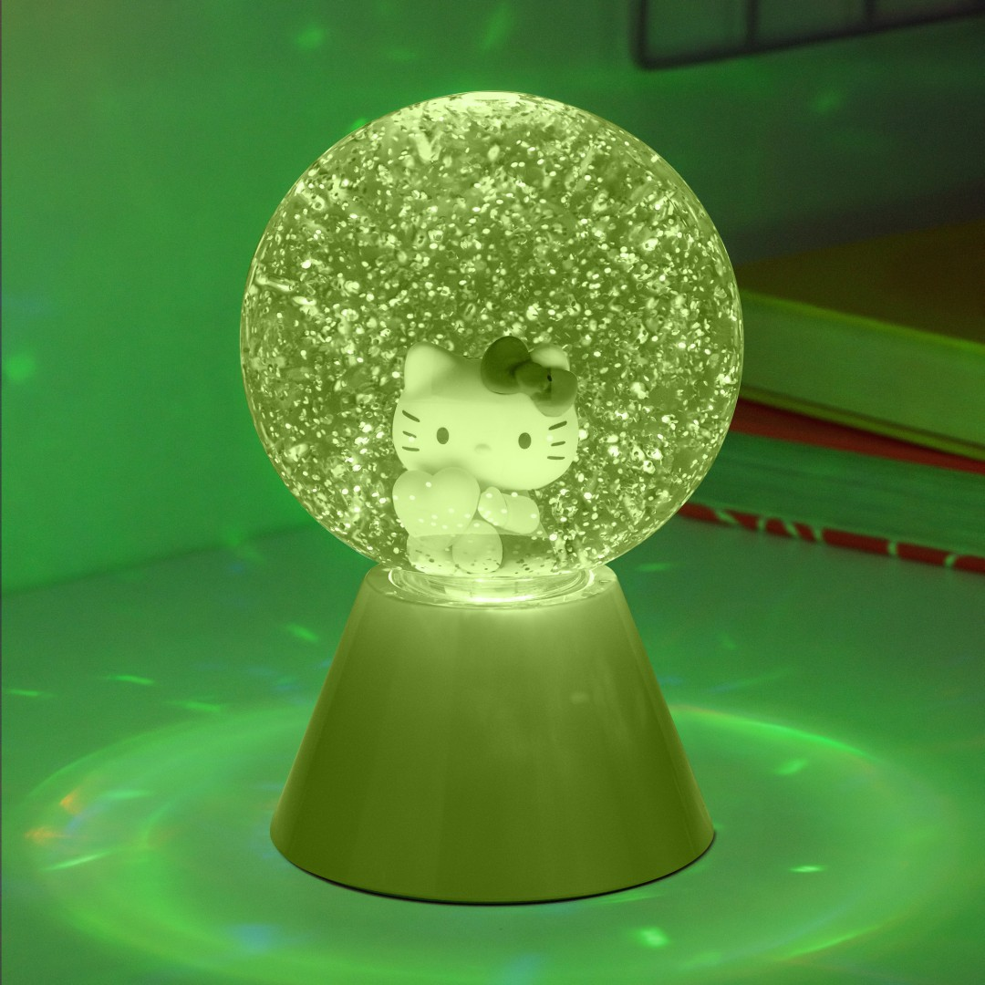 Lampa z kuli śnieżnej Hello Kitty na podstawie, podświetlona na zielono.