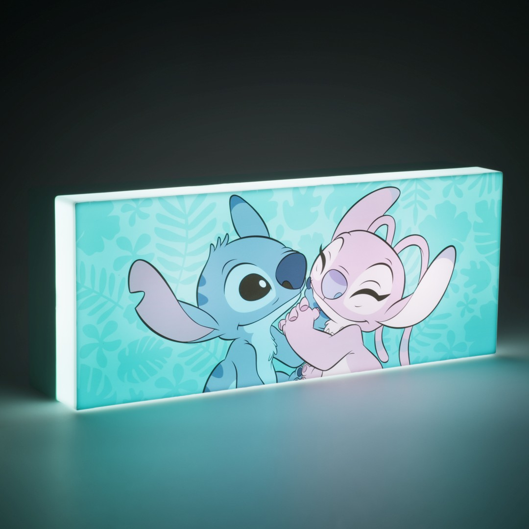 Niebieski i różowy Stitch przytulają się na niebieskim tle z wzorem liści.