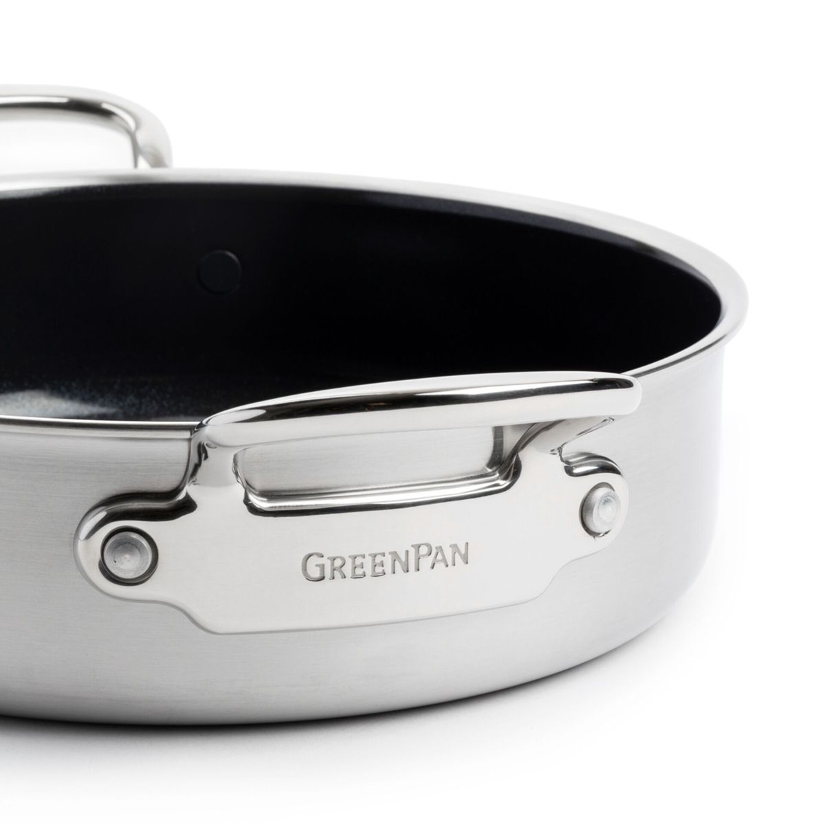 Nahaufnahme eines silbernen Kochtopfs mit schwarzem Innenraum und dem Logo "GREENPAN" auf dem Griff.