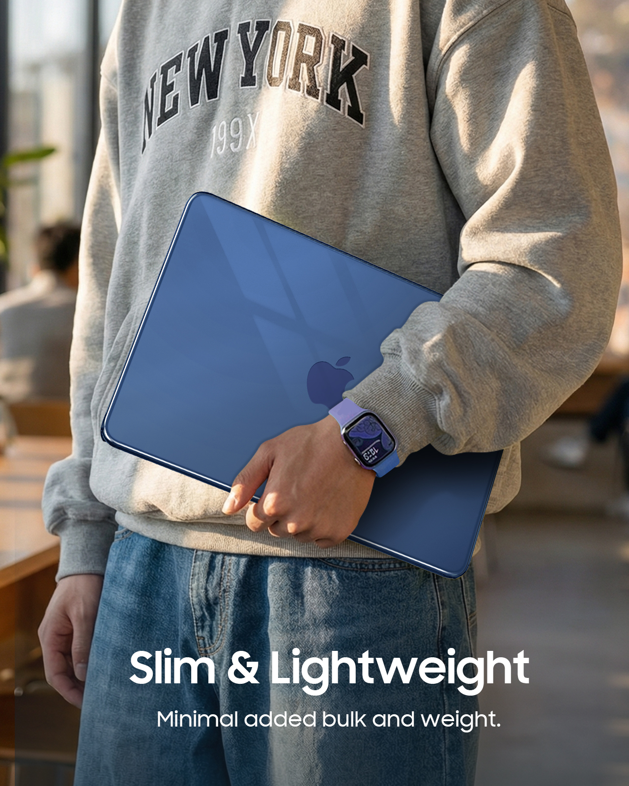 Person hält einen blauen Laptop mit Apple-Logo und eine Smartwatch am Handgelenk.