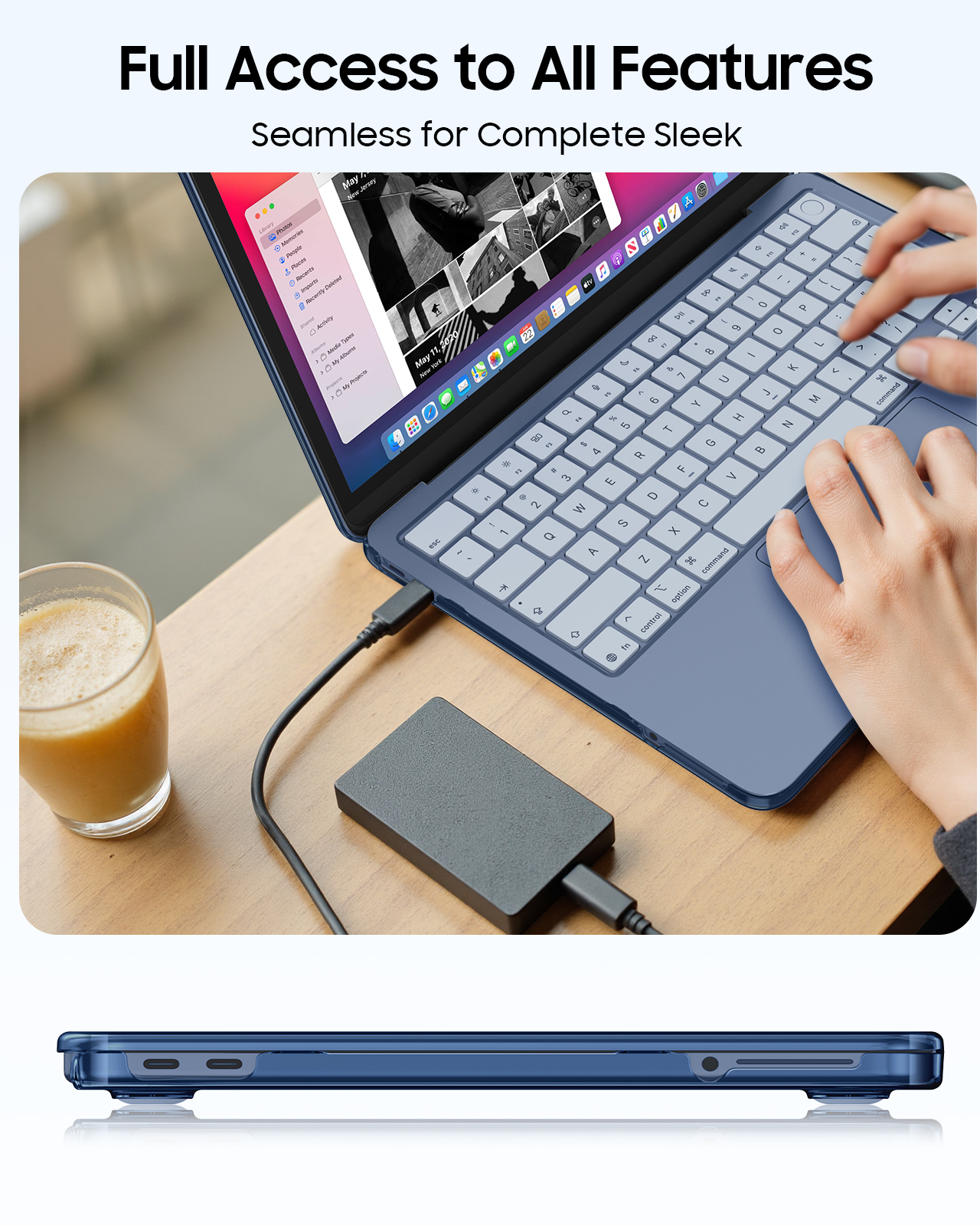 Ein blauer Laptop mit externer Festplatte und Getränk. Hände tippen auf der Tastatur.