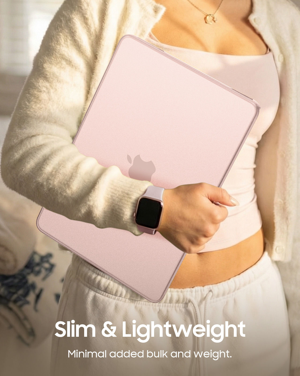 Eine Person hält einen rosafarbenen Laptop mit einem Apfel-Logo.