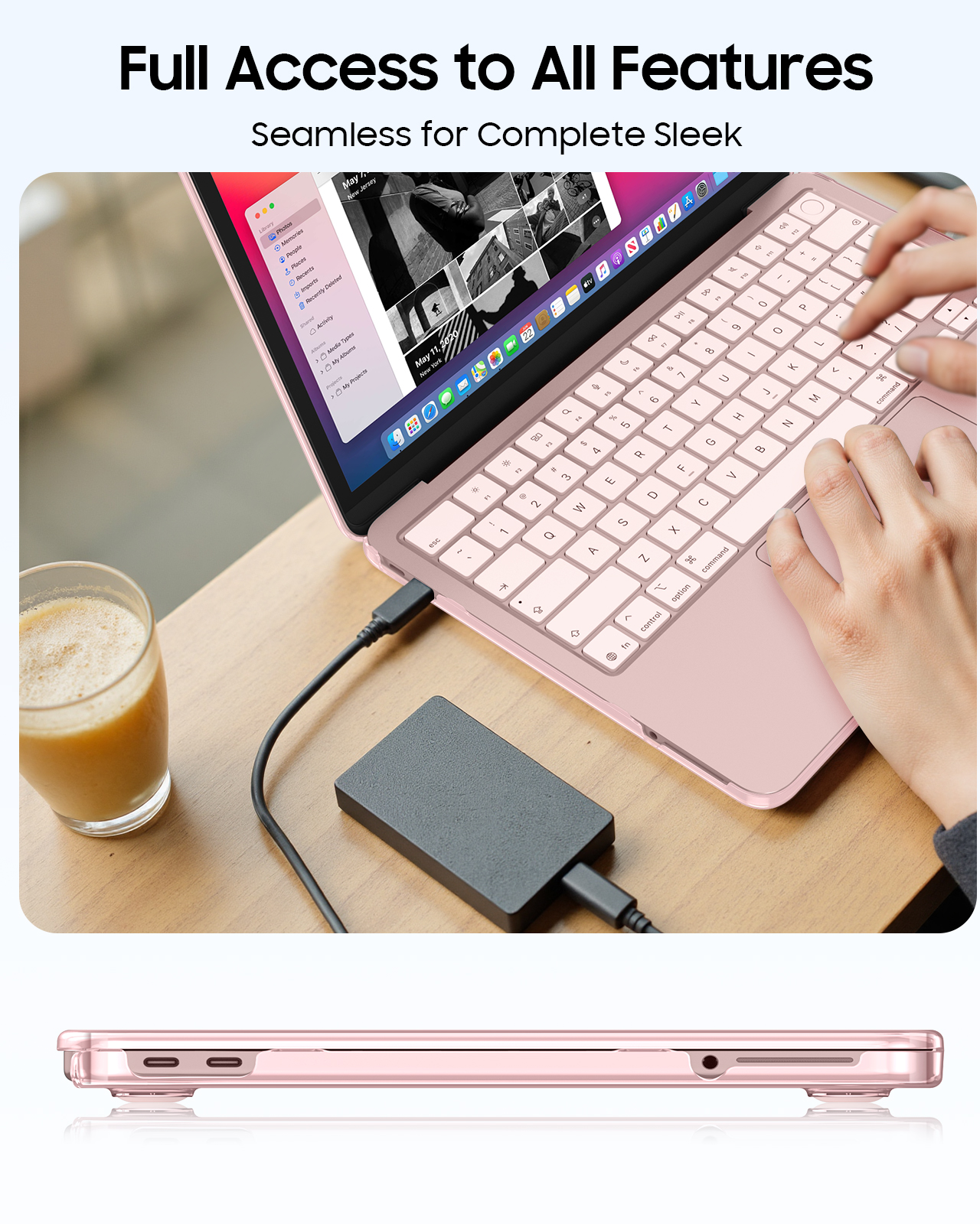Ein rosafarbener Laptop ist geöffnet, daneben ein Glas Getränk und eine externe Festplatte.