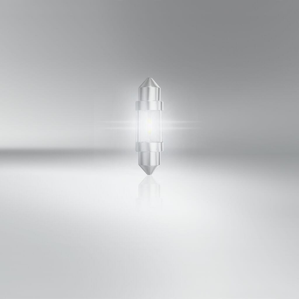 Eine silberne Glühbirne mit Glasgehäuse und leuchtendem Kern steht auf grauem Hintergrund.