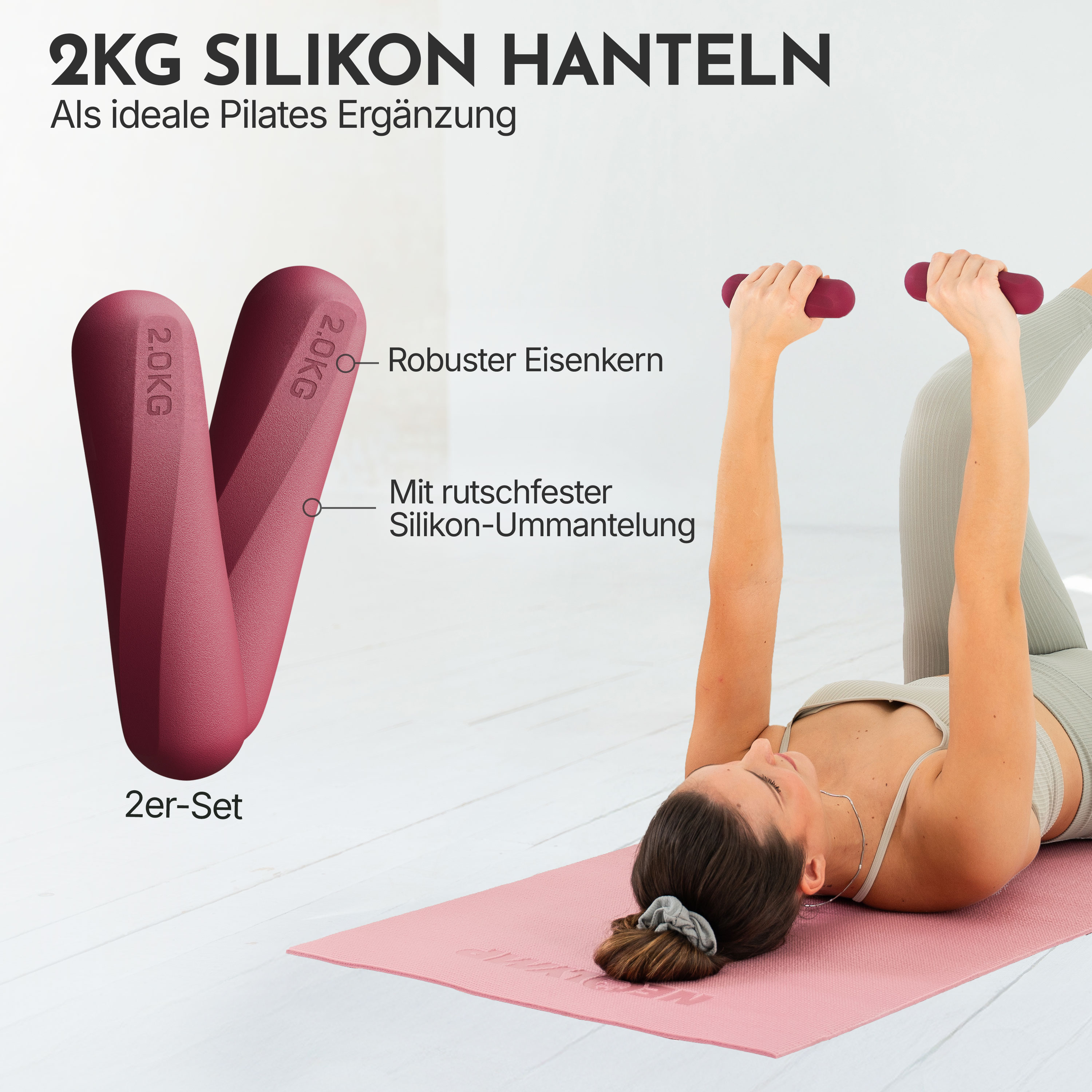 Eine Frau liegt auf einer rosa Matte und hebt zwei 2kg Hanteln mit roten Silikonüberzug.