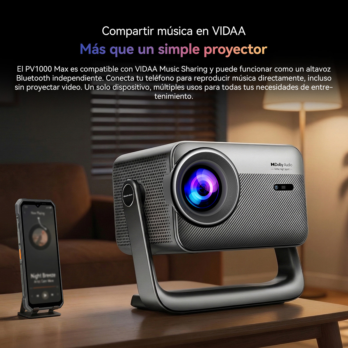 Un proyector gris está sobre una mesa, al lado un smartphone con app de música.
