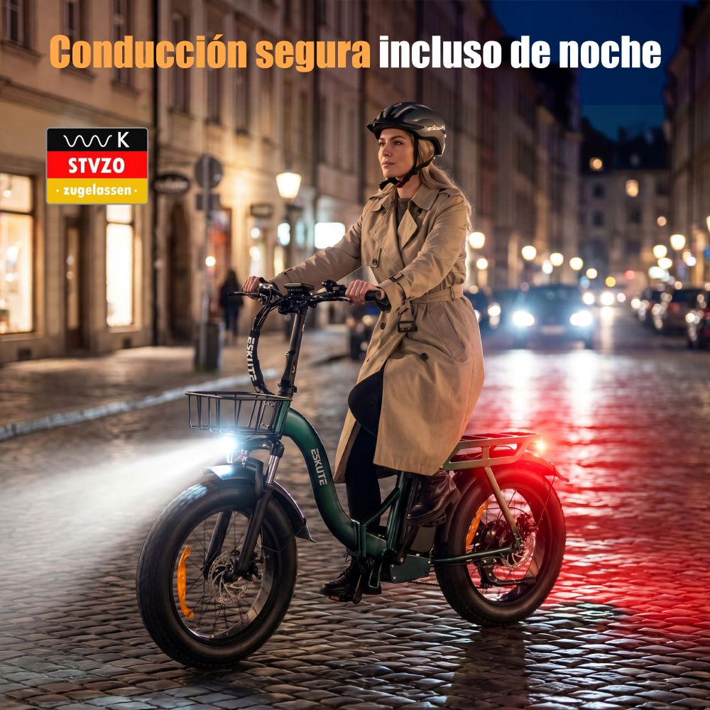 Mujer monta en bicicleta de noche con casco y abrigo beige en calle iluminada.