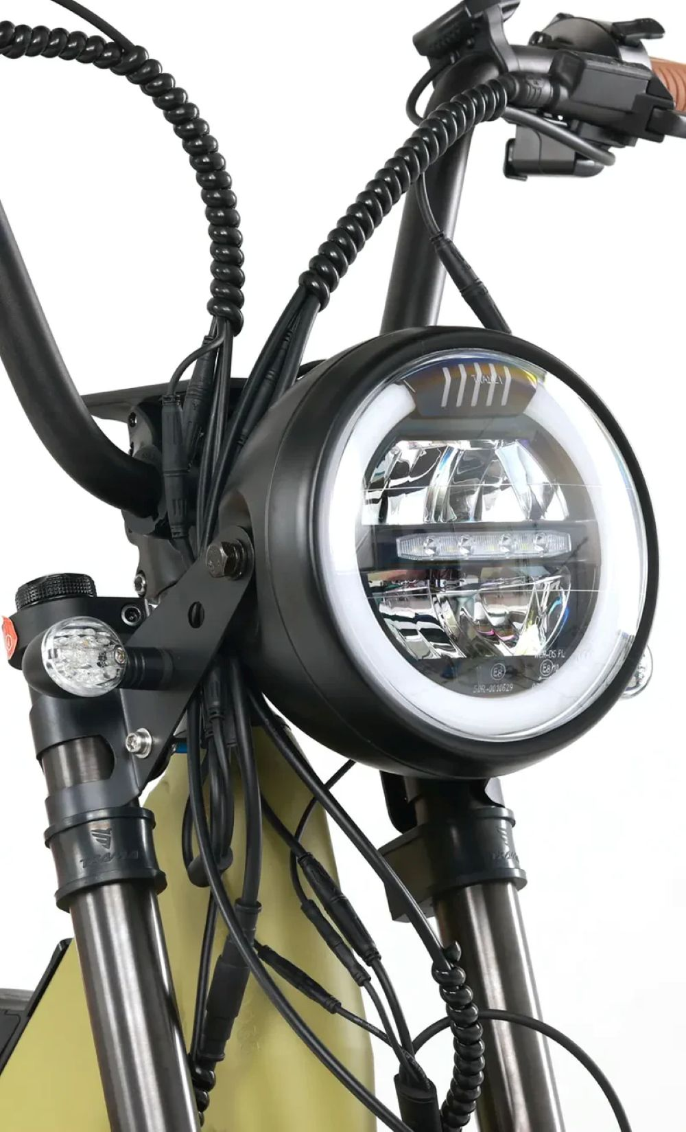 Faro redondo con anillo LED y cables en una moto.