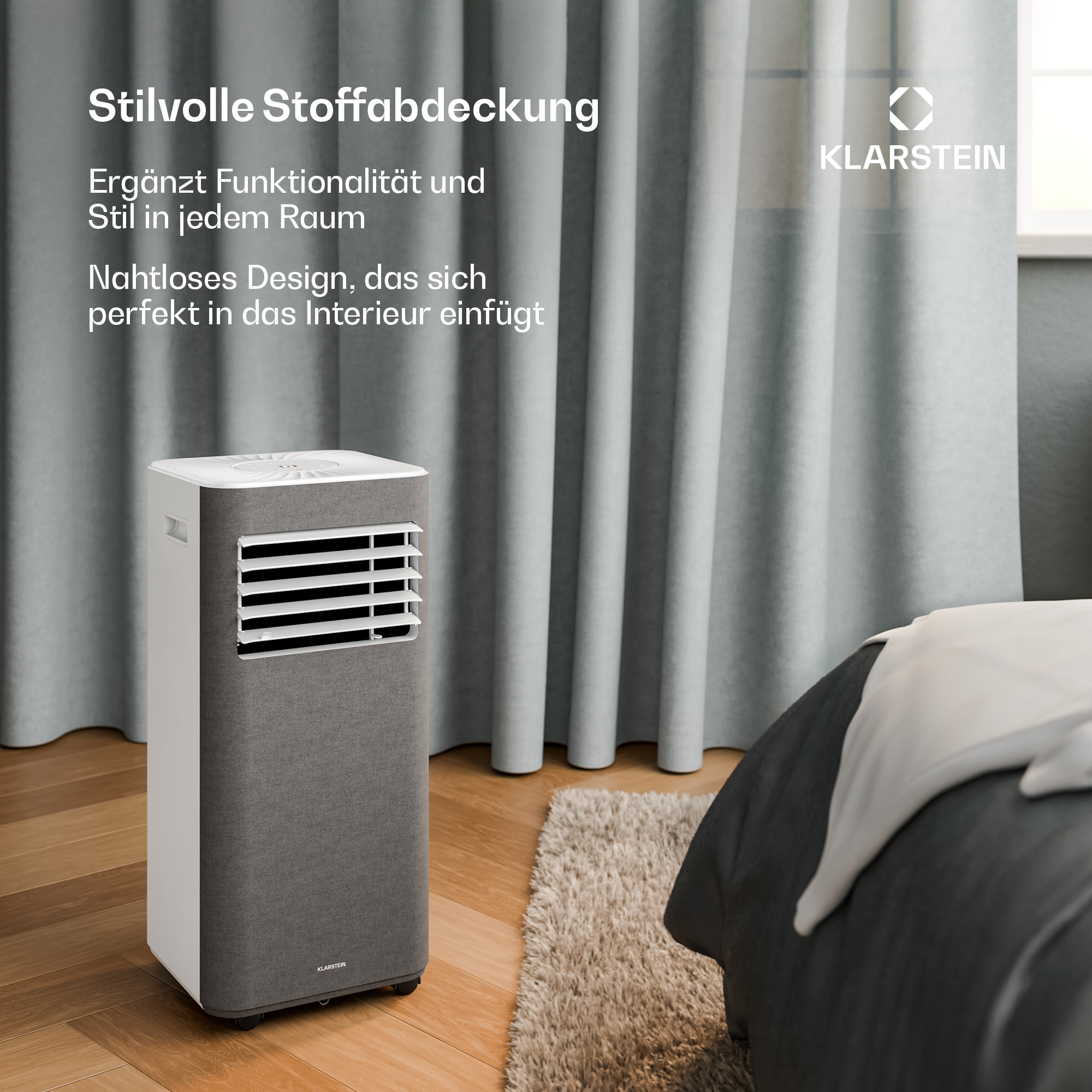 Un climatizzatore in tessuto grigio si trova su un pavimento in legno accanto a un letto.
