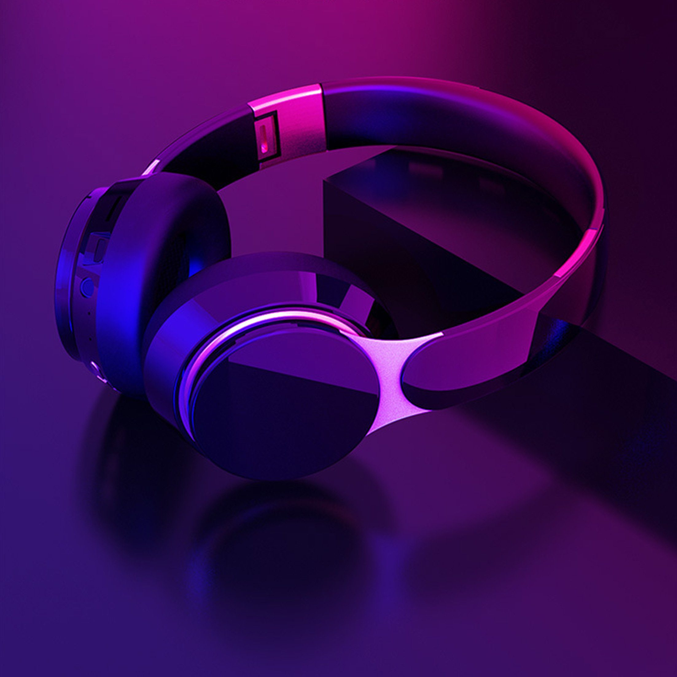 Schwarze Kopfhörer mit pink-blauer Beleuchtung auf dunklem Hintergrund.