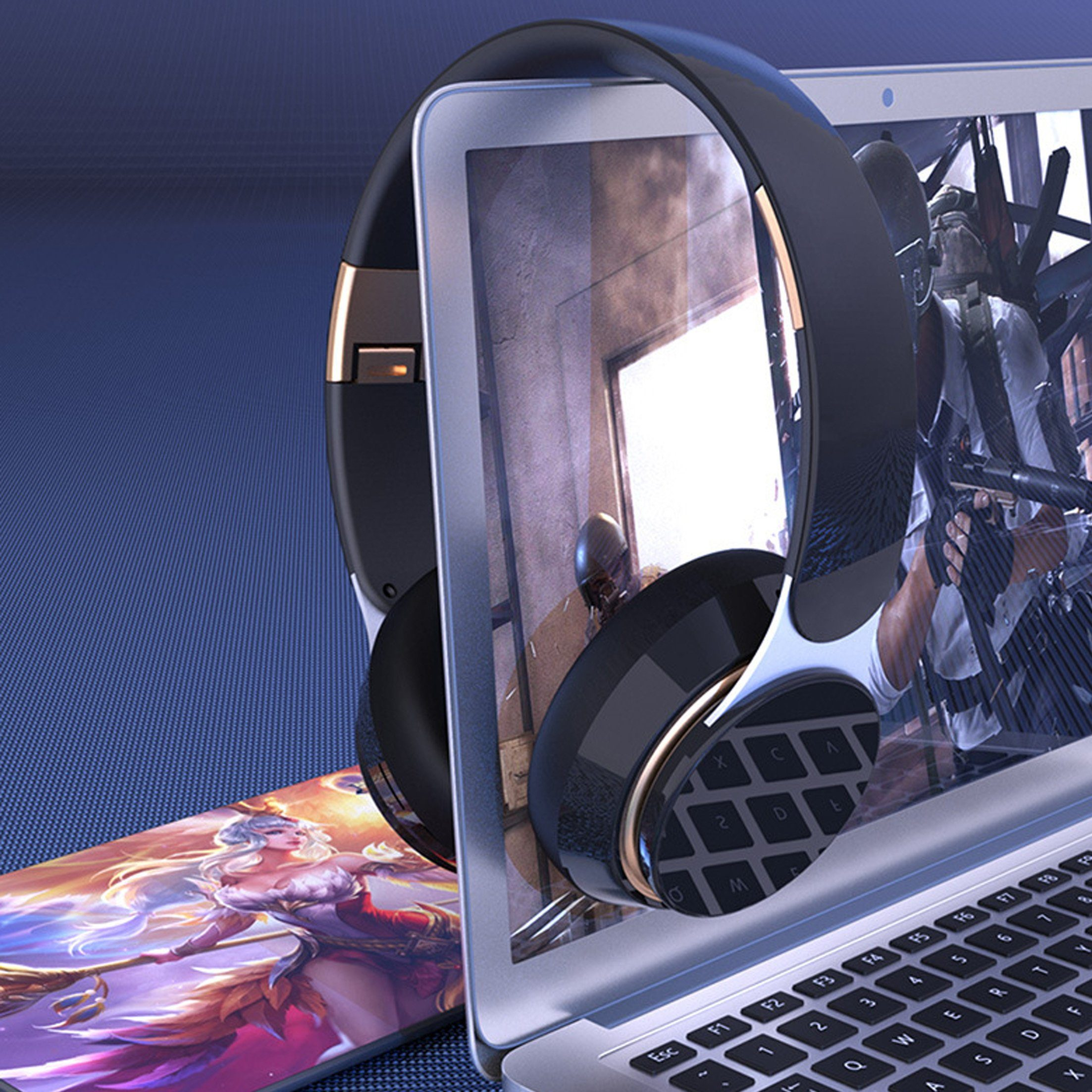 Kopfhörer über einem Laptop mit Spiel und einem Smartphone mit Fantasy-Kunst.