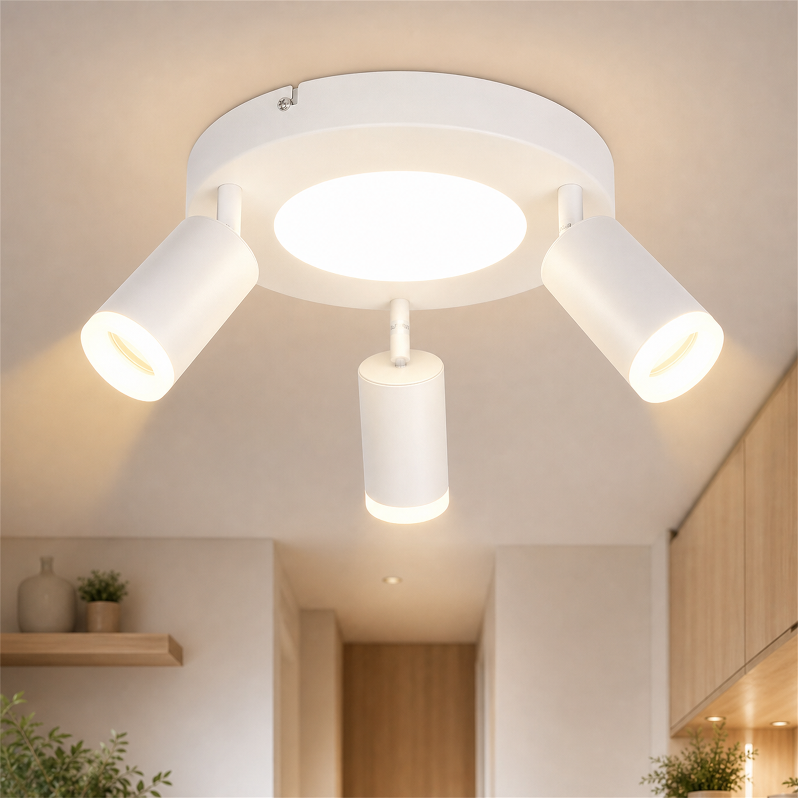 Lampada da soffitto con tre faretti bianchi e illuminazione centrale su base rotonda.