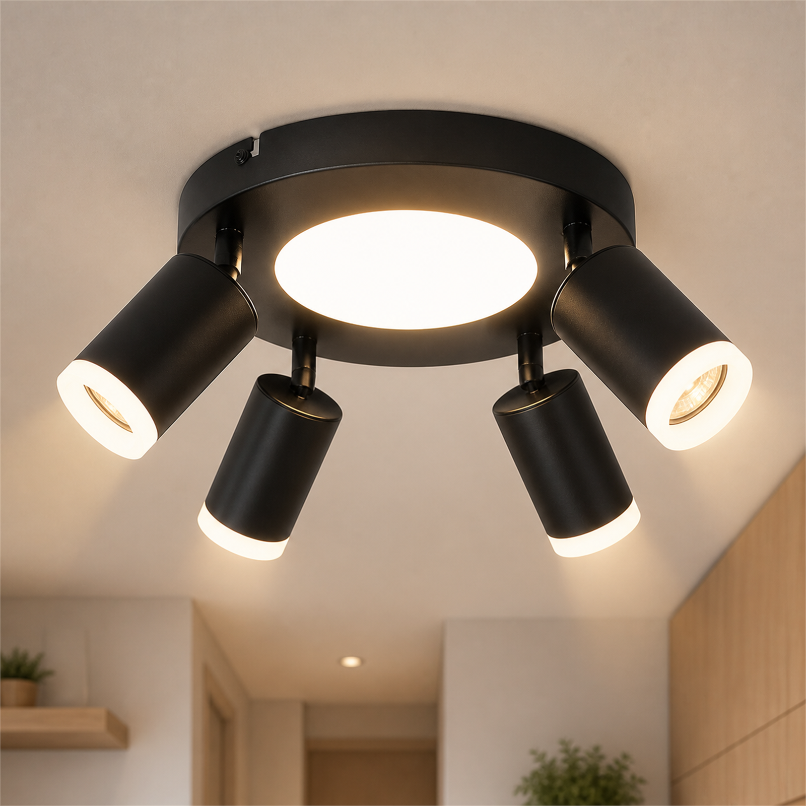 Plafoniera nera con quattro faretti orientabili e illuminazione centrale.