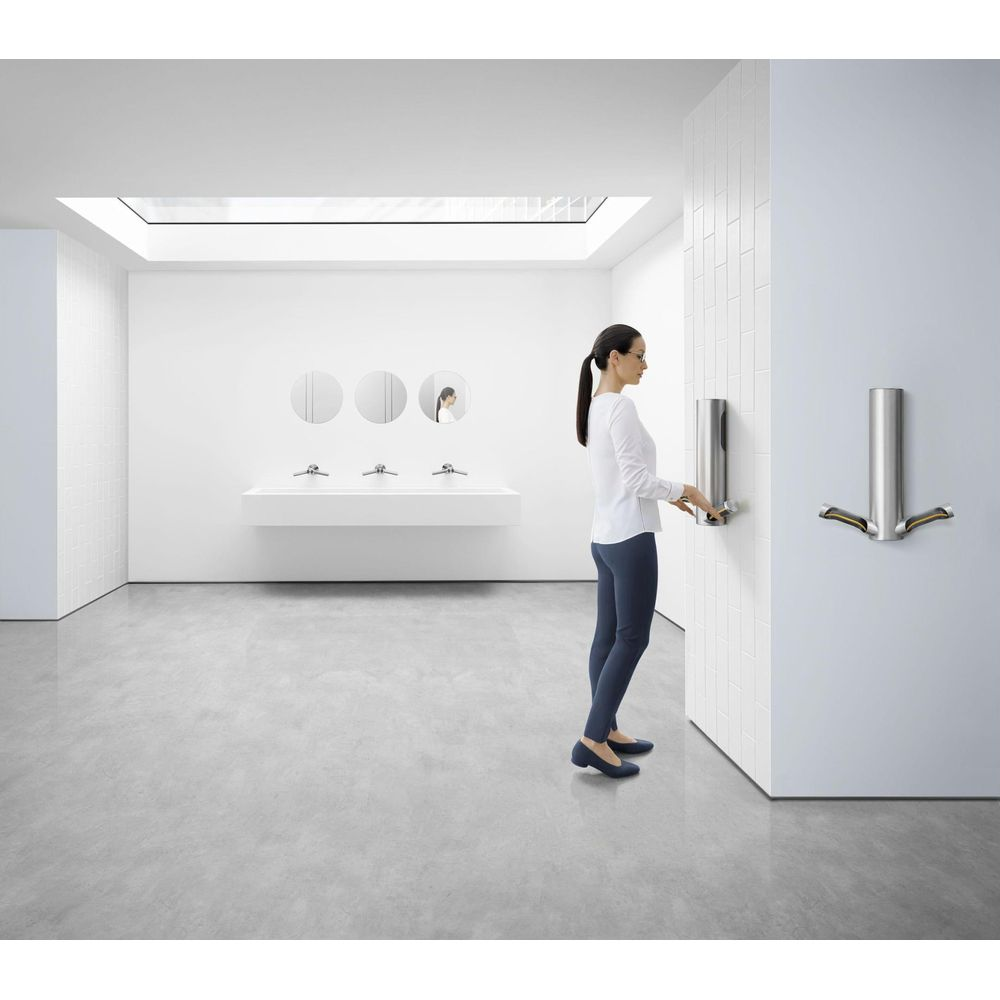 Una donna usa un asciugamani per le mani in un bagno moderno e bianco.