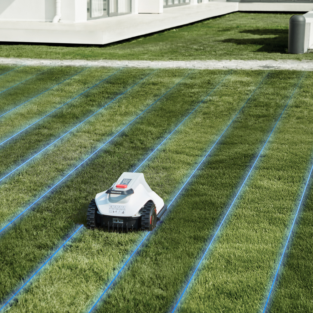 A white robotic lawn mower on grass with blue lines.