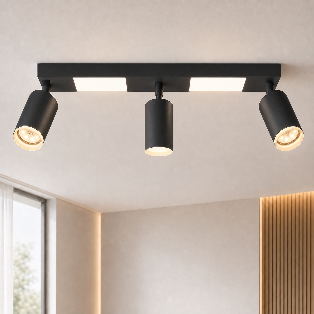 Faretti da soffitto neri con tre spot cilindrici sopra una barra essenziale.