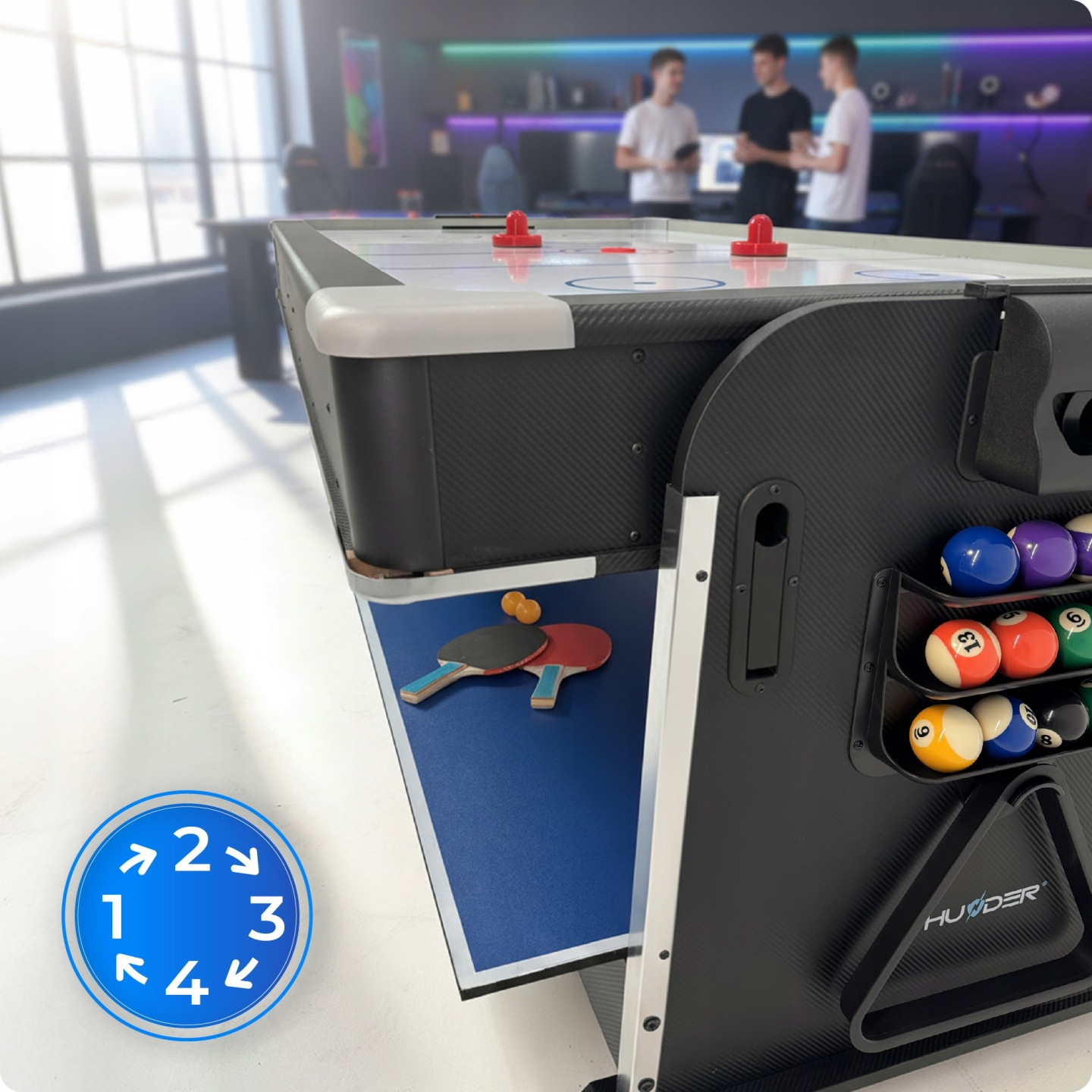 Ein Multi-Game-Tisch mit Airhockey, Tischtennis und Billard. Im Hintergrund stehen drei Personen.