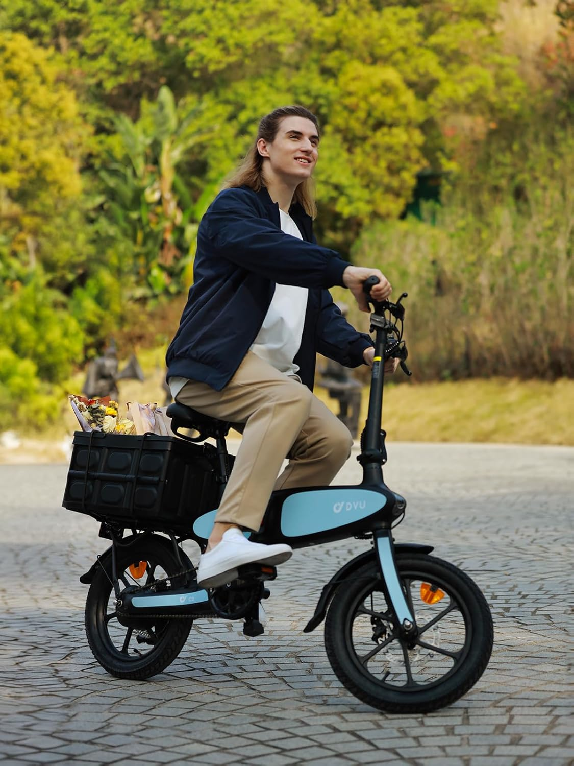 Un hombre de pelo largo monta una bicicleta eléctrica azul claro con cesta.