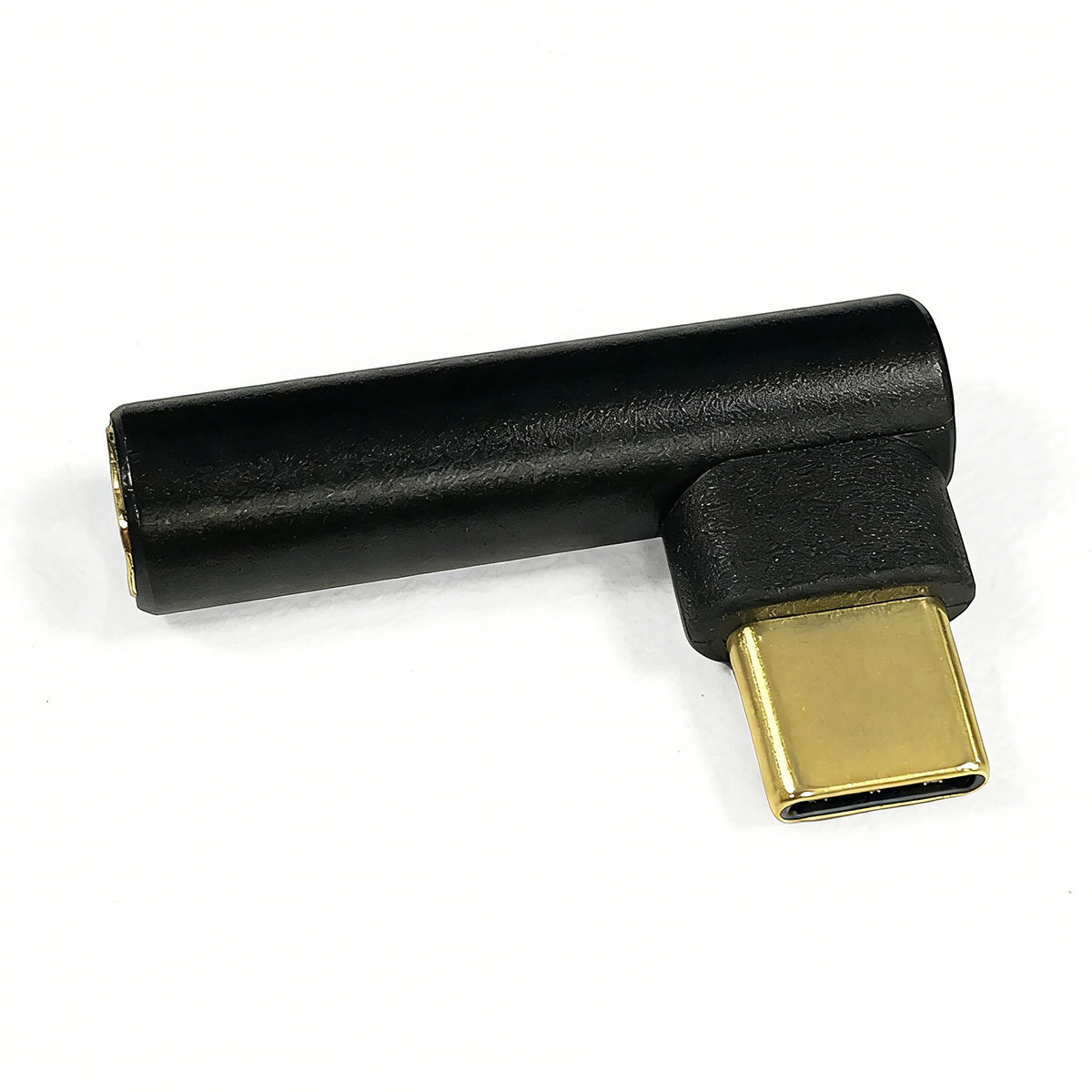 Ein schwarzer 90-Grad-USB-C-Adapter mit goldenem Stecker liegt auf weißem Hintergrund.