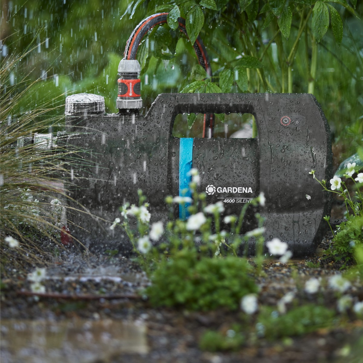 Un dispositivo da giardino nero con attacco per tubo sotto la pioggia.