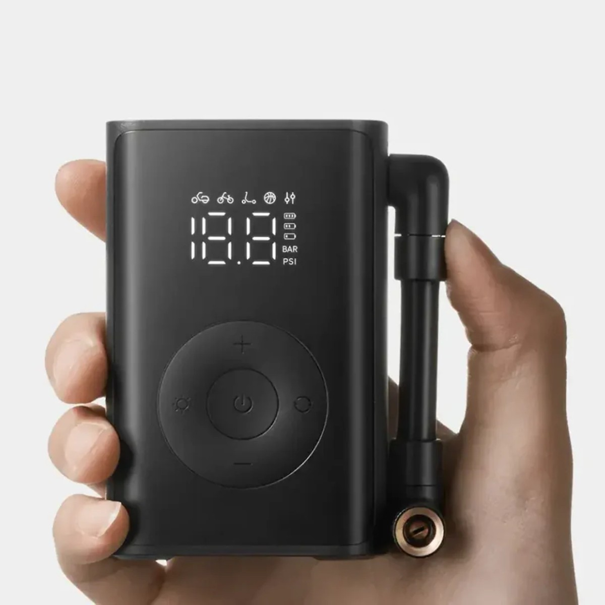 Una mano tiene un gonfiatore portatile per pneumatici nero con display digitale.