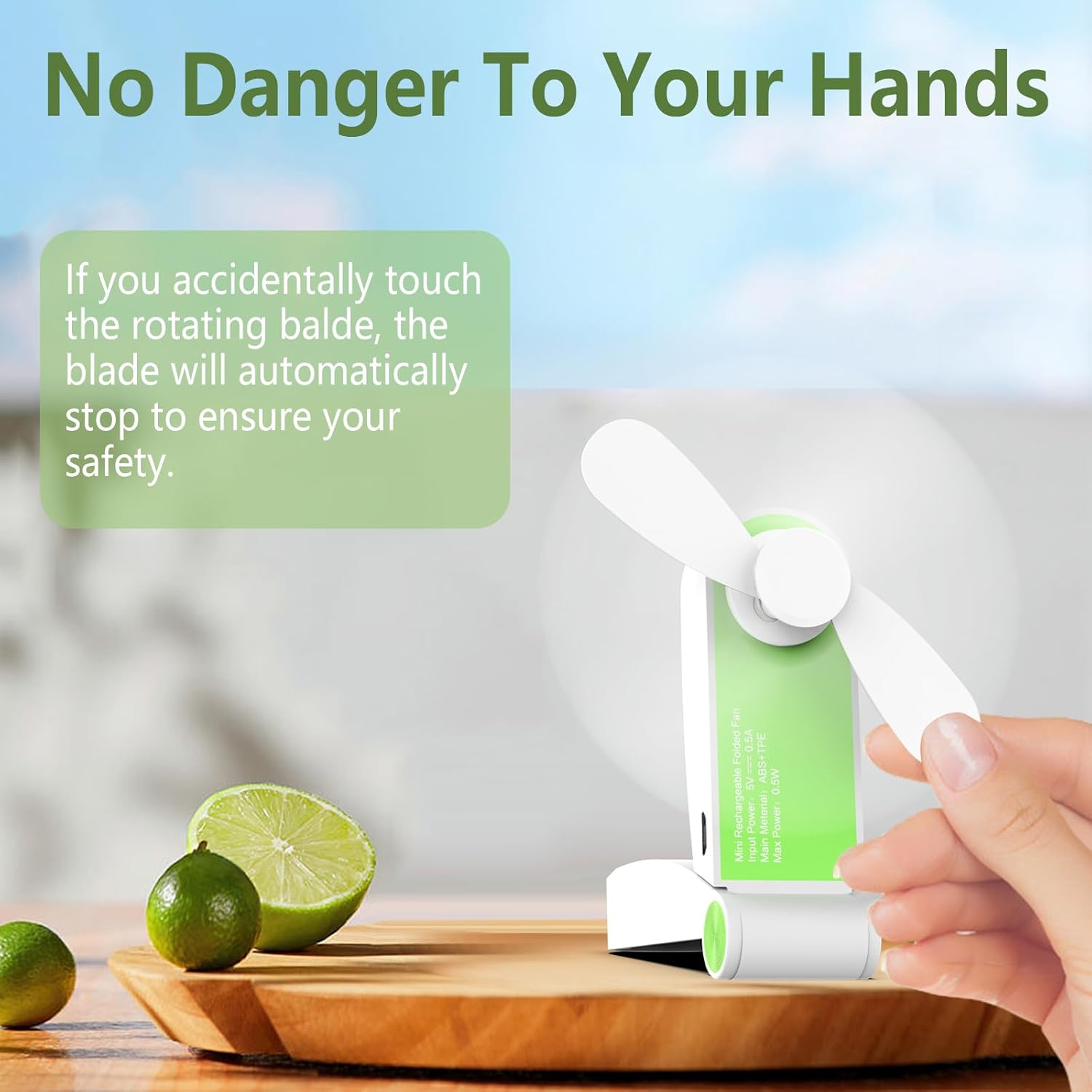 Grüner Mini-Ventilator wird von einer Hand gehalten, neben Limetten.
