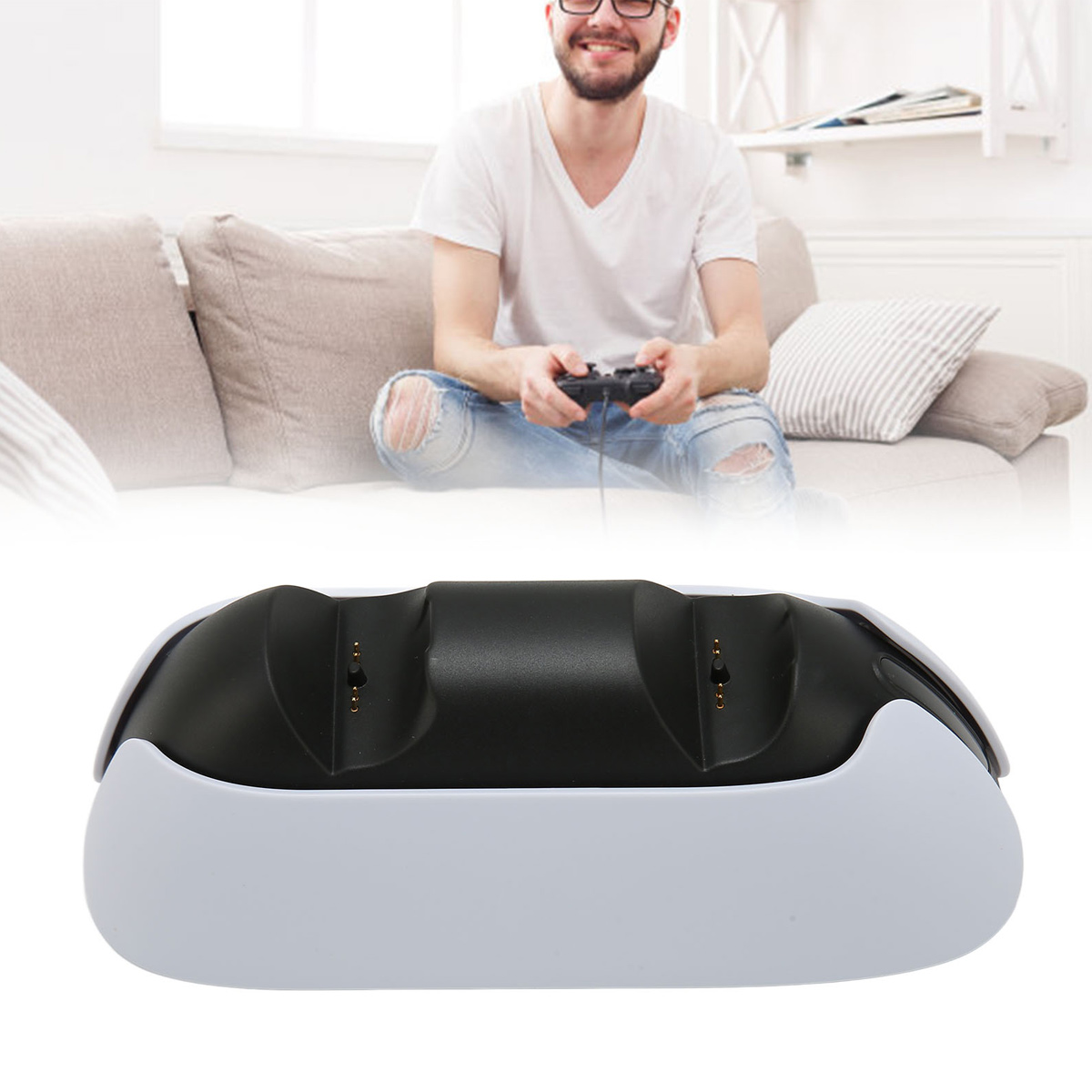 Mann im weißen T-Shirt spielt Videospiele auf Couch mit Controller; schwarzer und weißer Ladeständer.