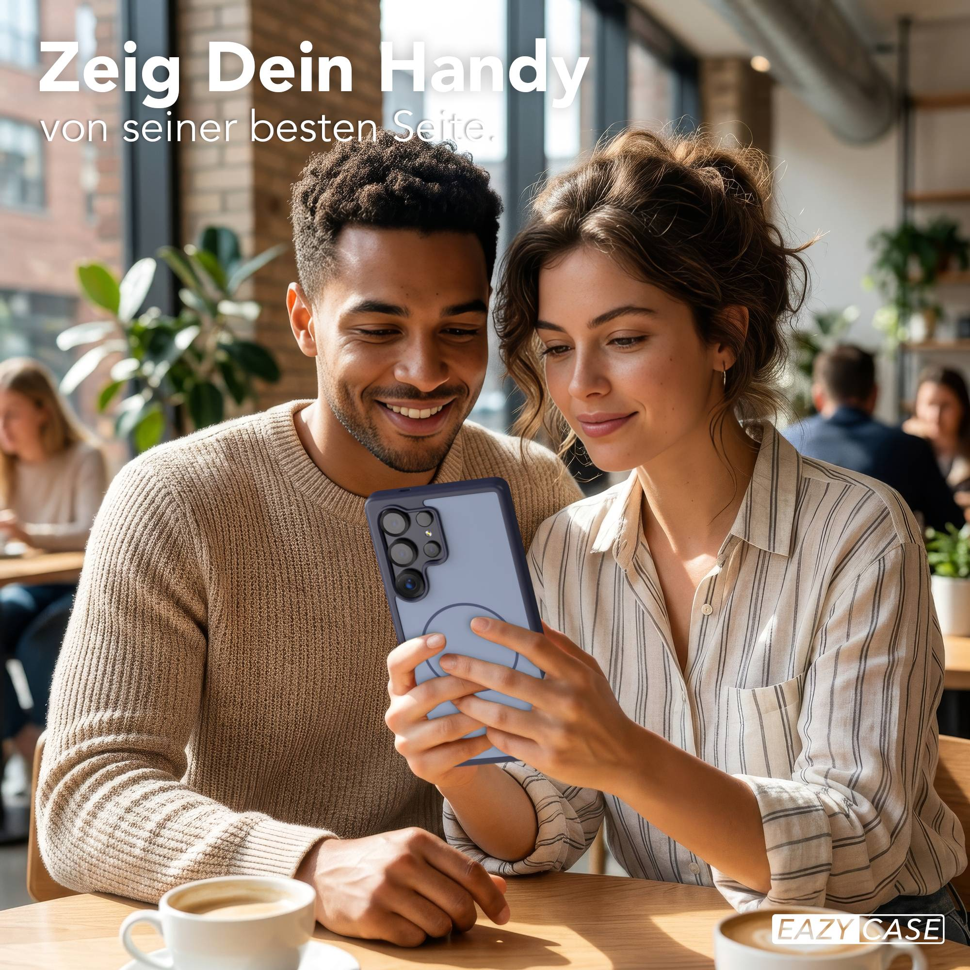 Ein Mann und eine Frau schauen auf ein Handy in einem Café.
