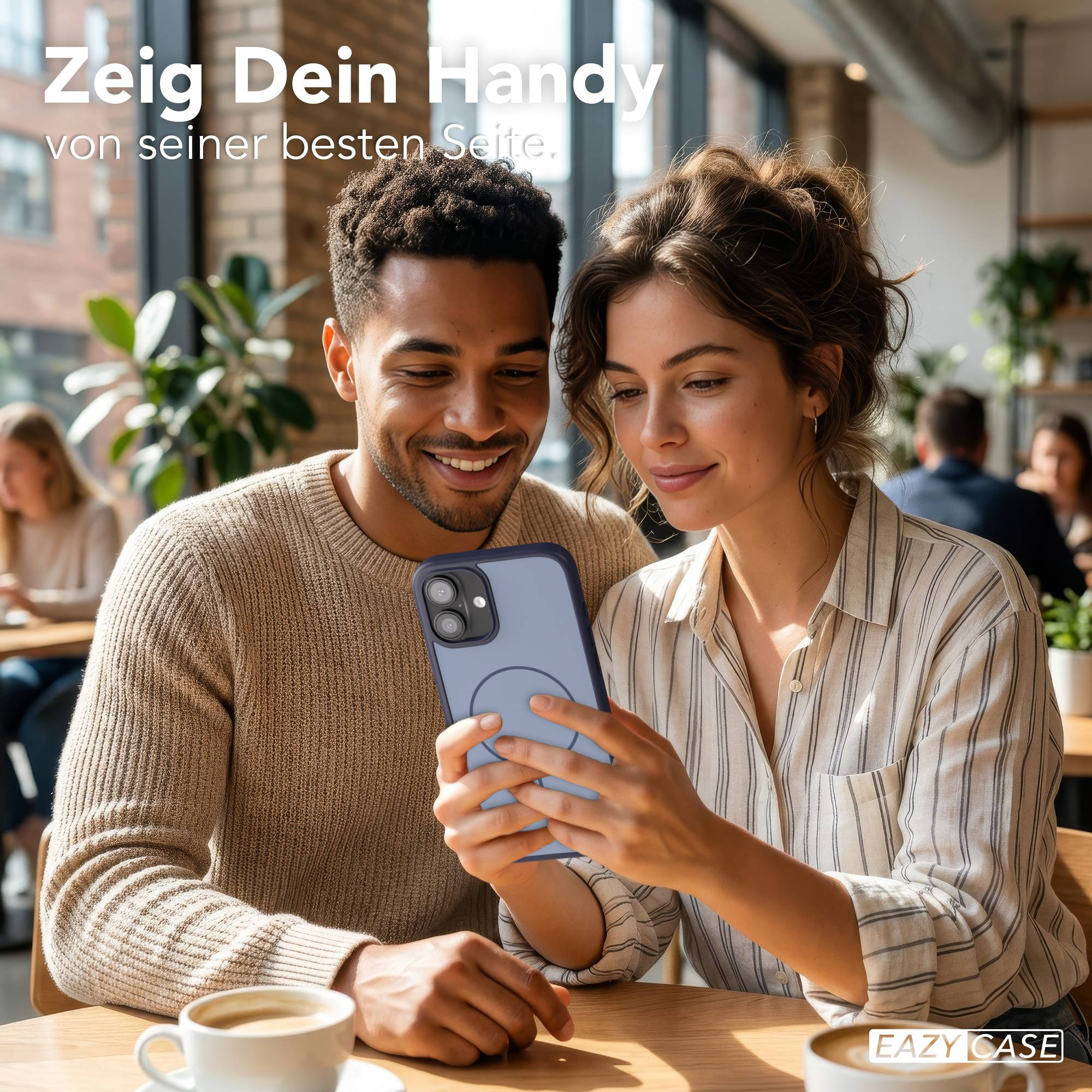 Ein Mann und eine Frau schauen auf ein Handy in einem Café.