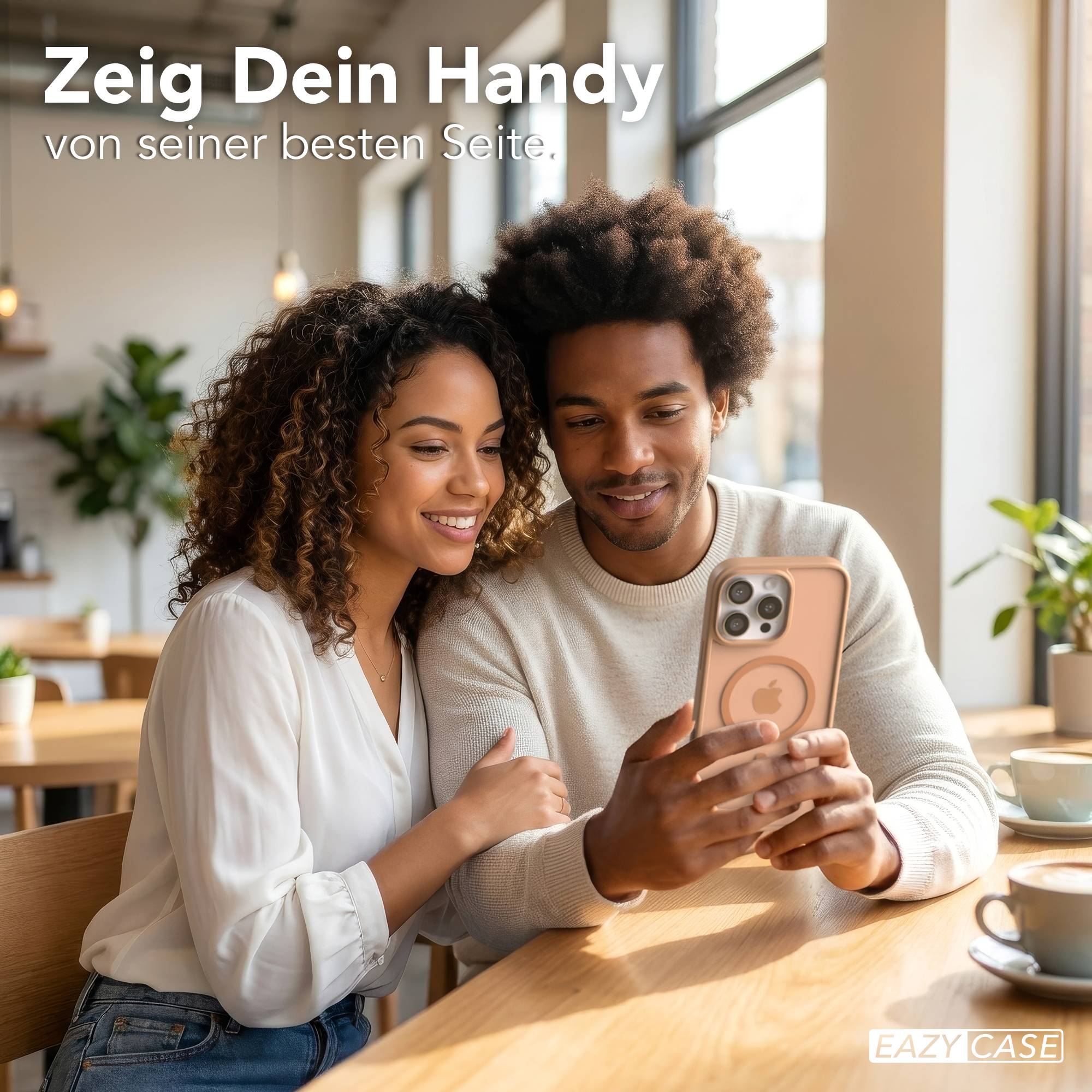 Ein Mann und eine Frau sitzen an einem Holztisch und betrachten ein Handy.