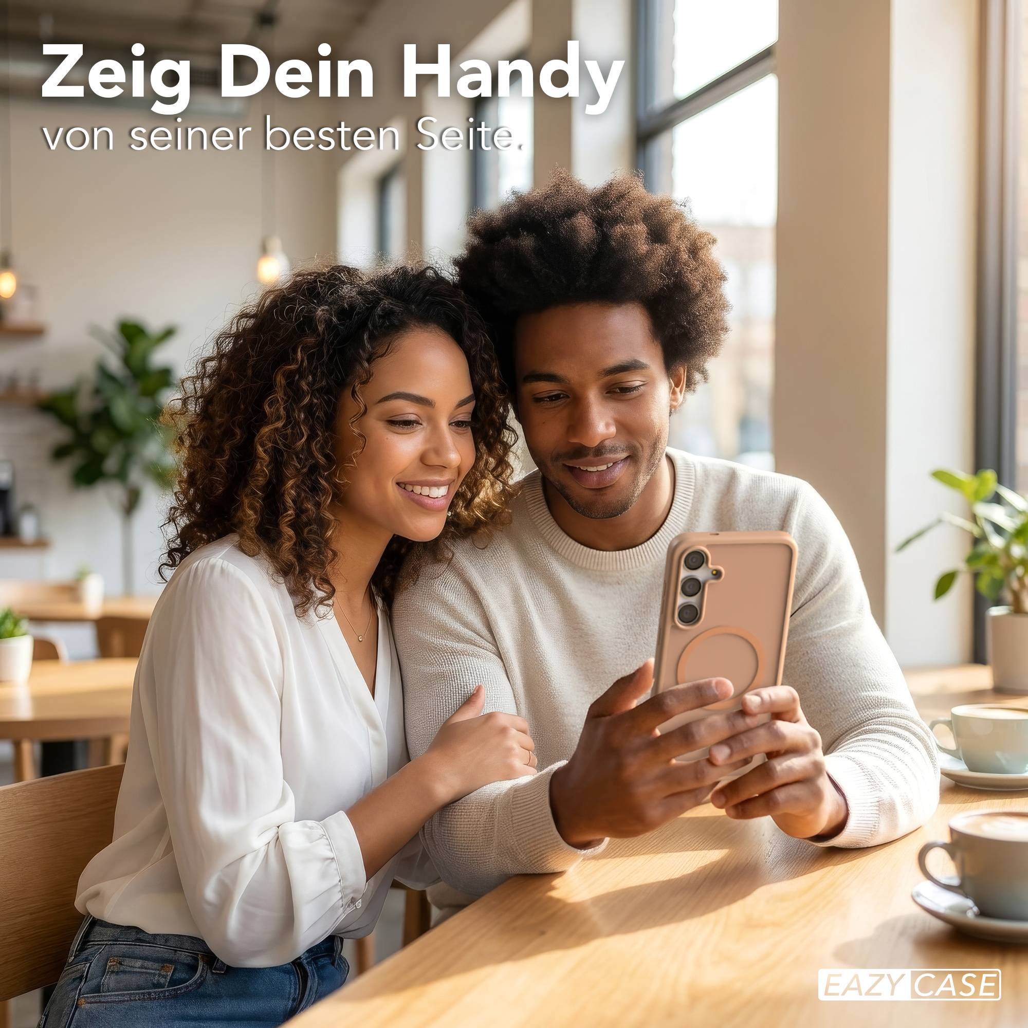 Ein Mann und eine Frau sitzen an einem Tisch und schauen auf ein Handy.
