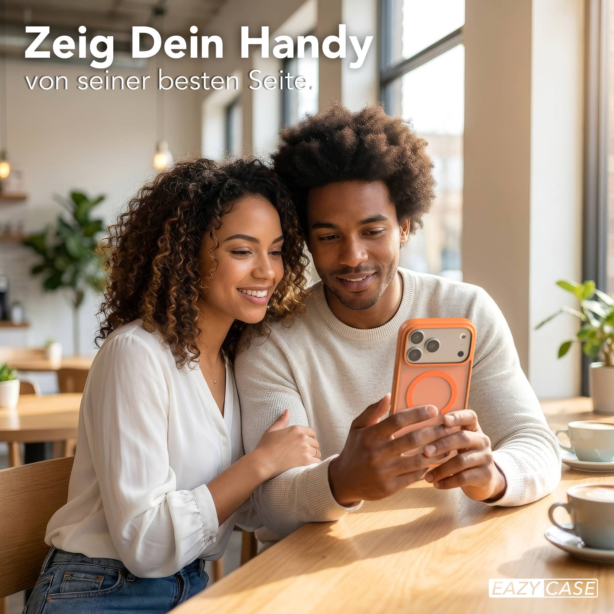 Ein Mann und eine Frau sitzen an einem Holztisch und betrachten ein Handy.