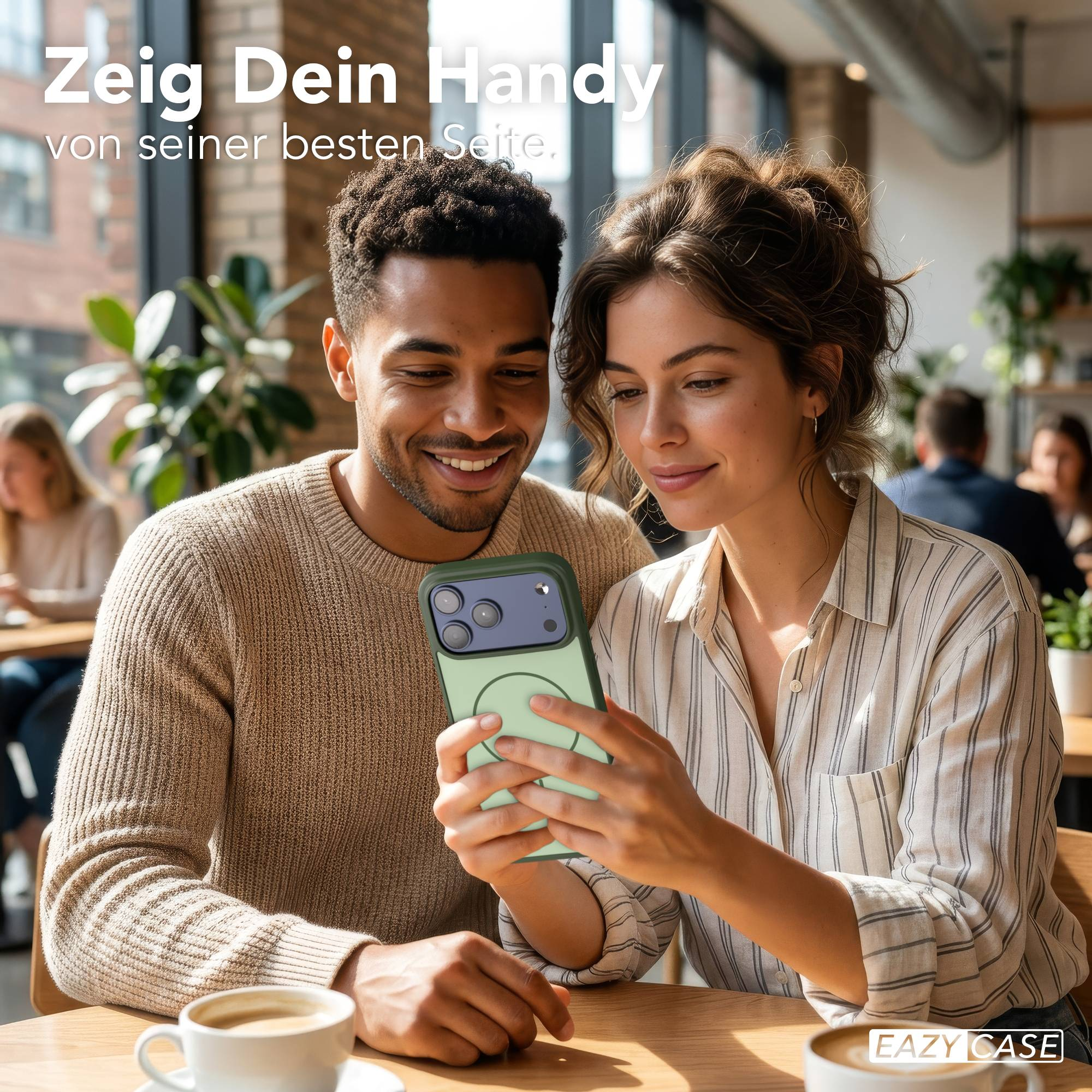 Ein Mann und eine Frau sitzen in einem Café und schauen auf ein Handy.
