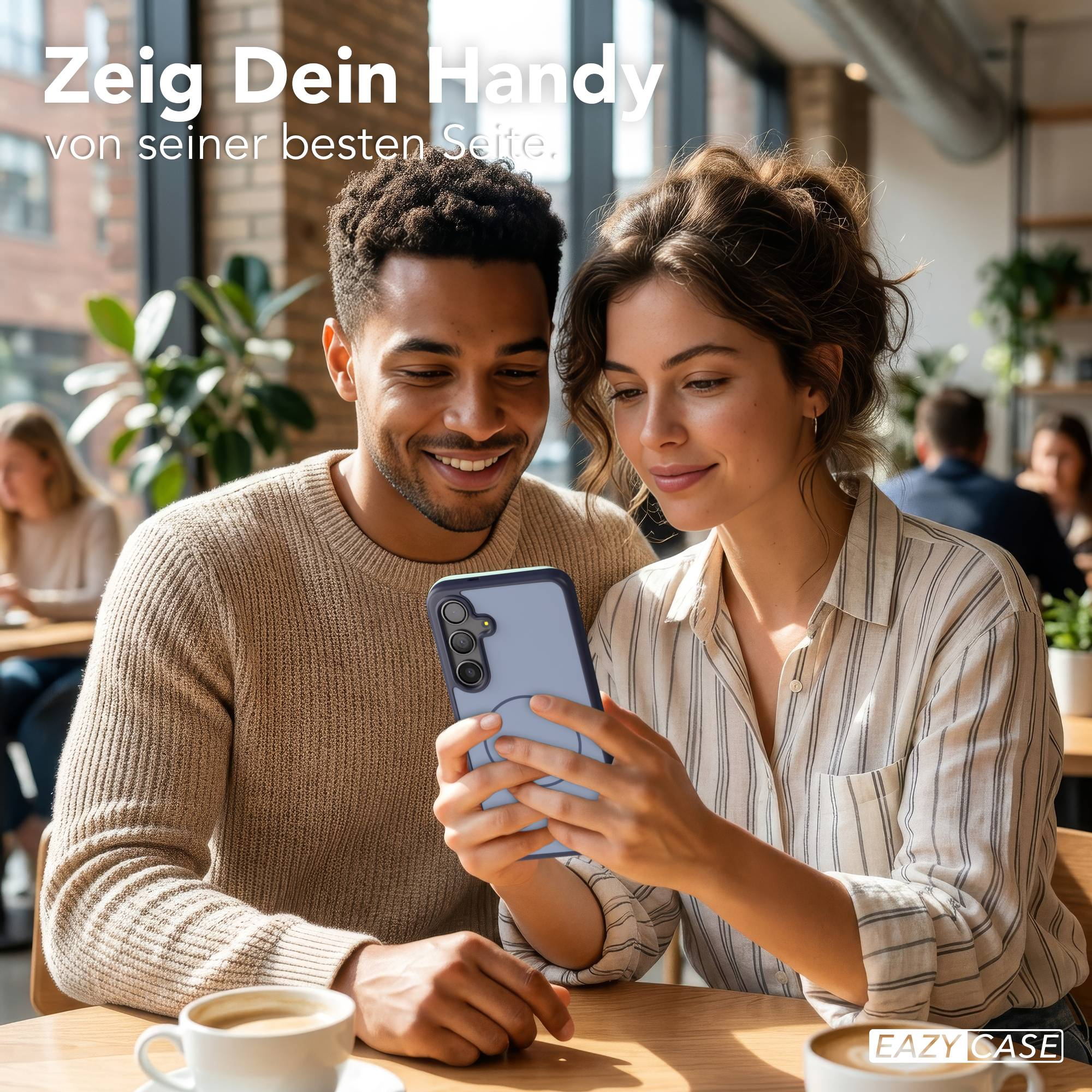 Ein Mann und eine Frau betrachten lächelnd ein Handy in einem Café.