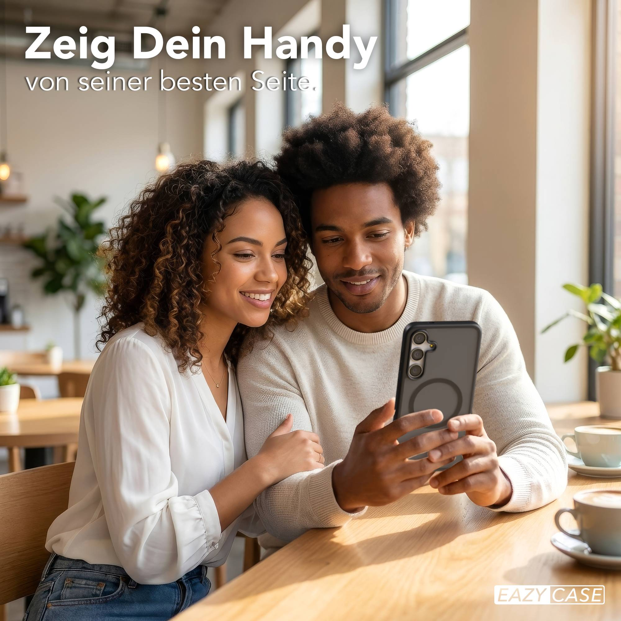 Ein Mann und eine Frau betrachten lächelnd ein Smartphone in einem Café.