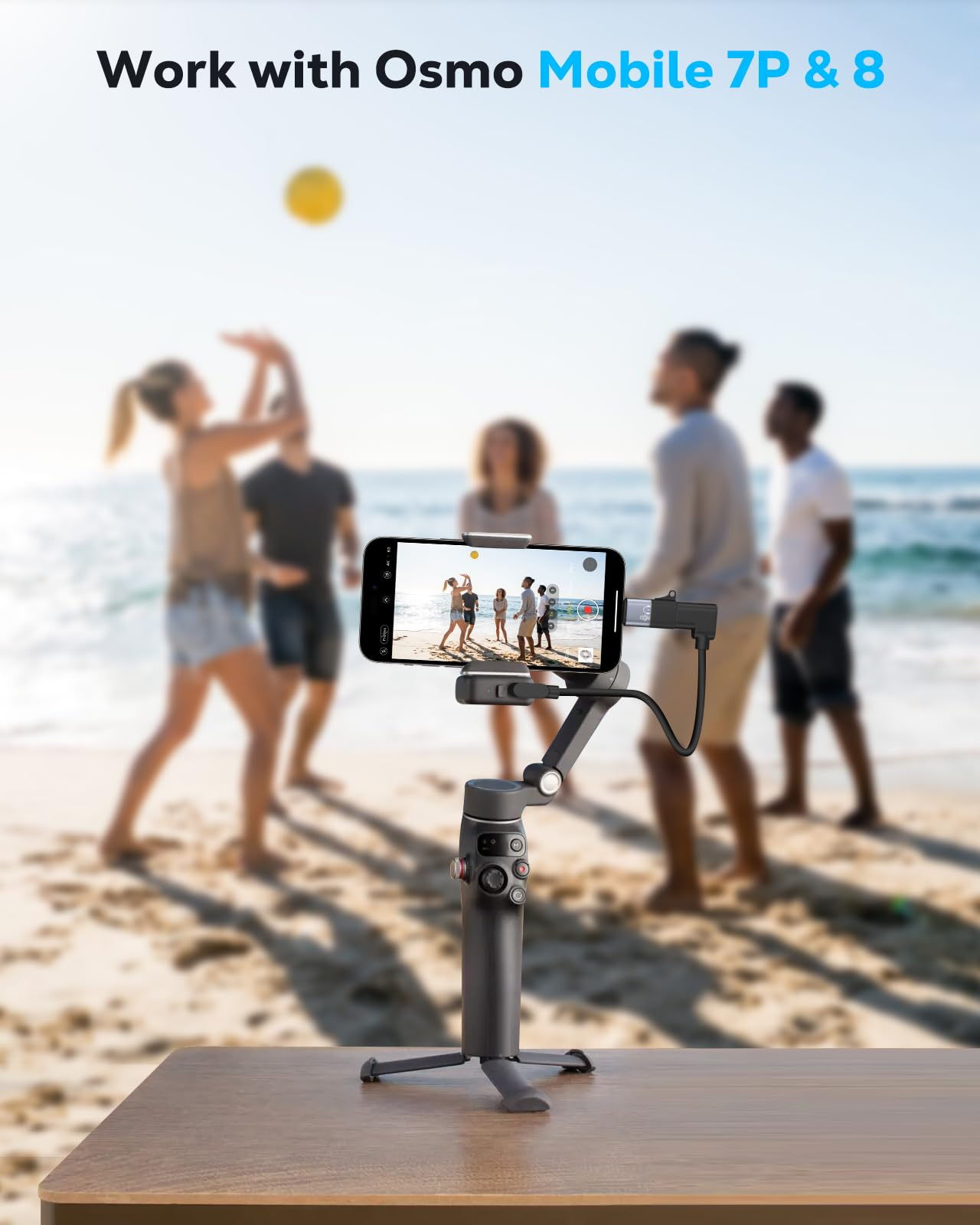 Ein Gimbal mit Smartphone filmt eine Gruppe von Leuten am Strand, die Beachball spielen.