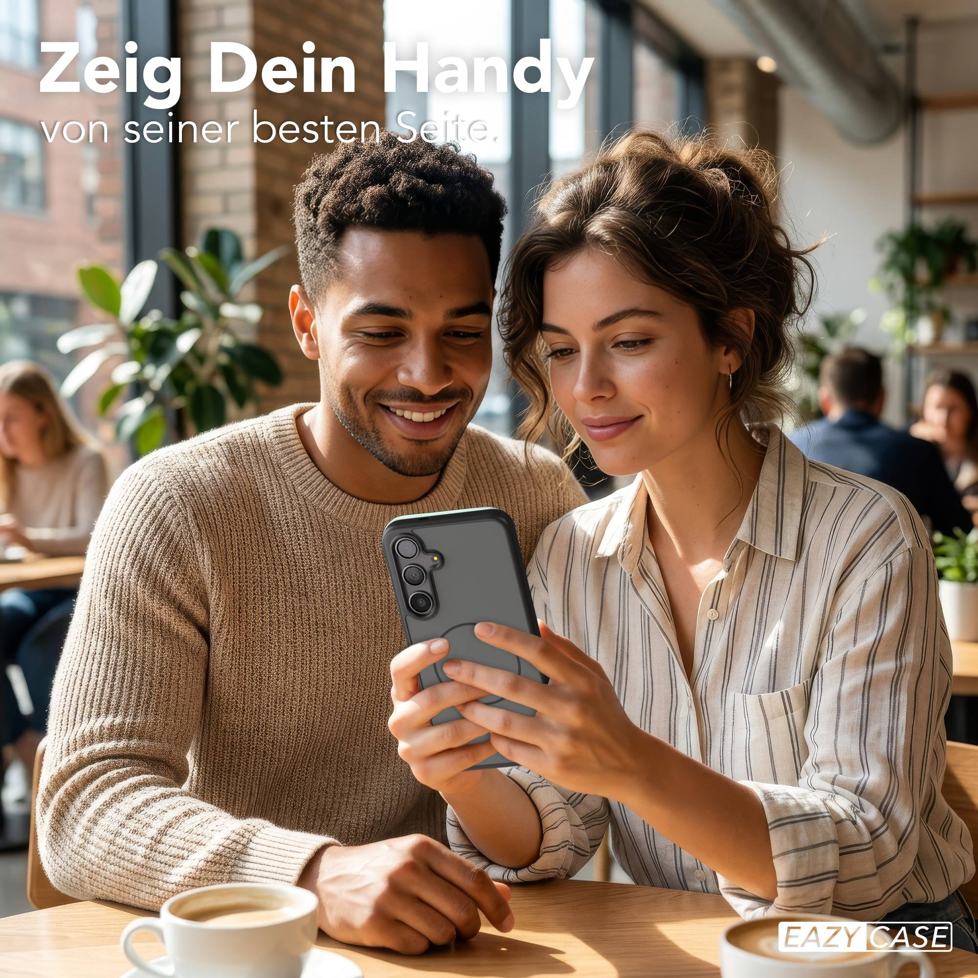 Ein Mann und eine Frau betrachten ein Handy in einem Café.