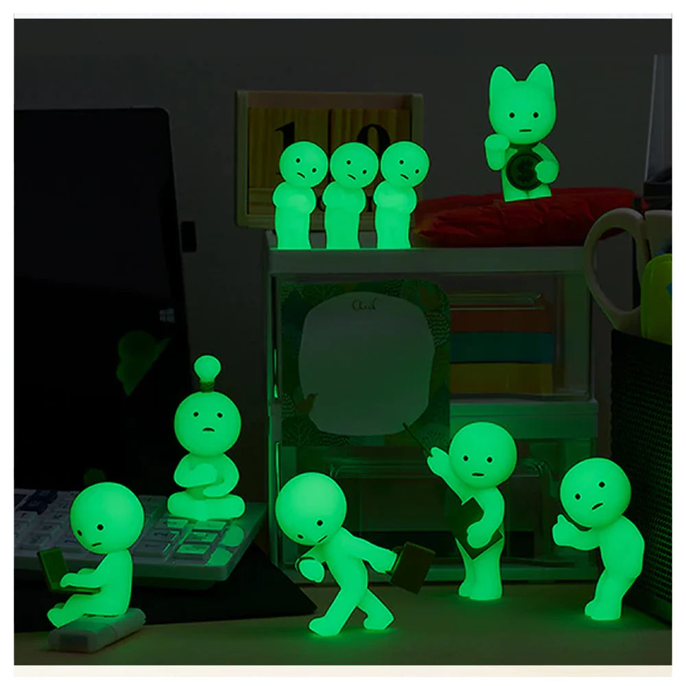 Leuchtende Figuren auf einem Schreibtisch: eine mit Laptop, eine meditierend, eine rennend.