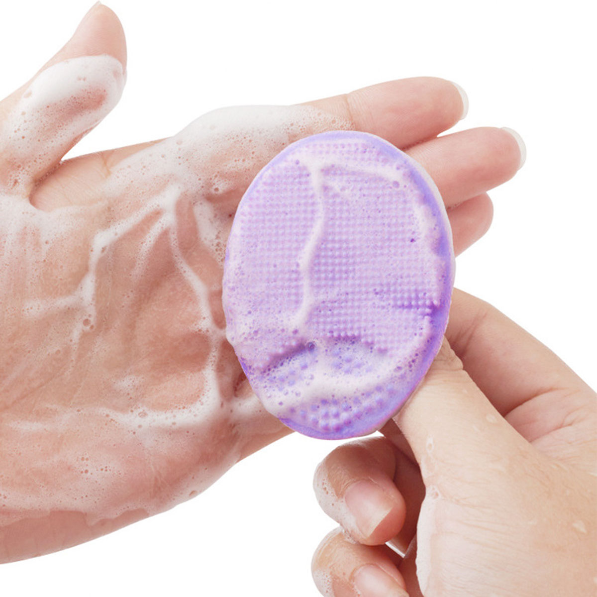 Eine Hand hält einen lilafarbenen Gesichtsreiniger mit Schaum.