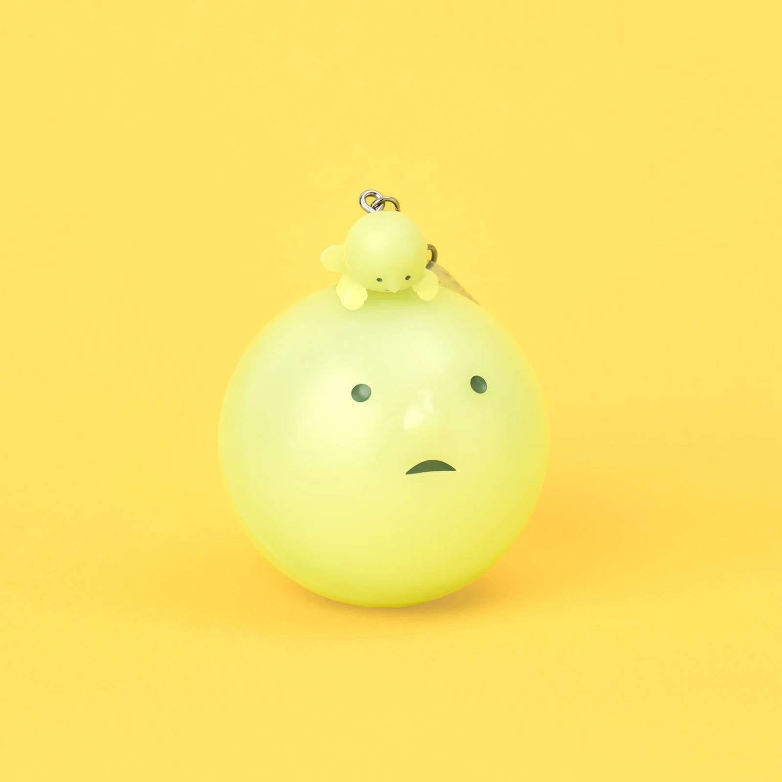 Eine kleine hellgrüne Figur sitzt auf einer größeren hellgrünen Kugel mit Gesicht.