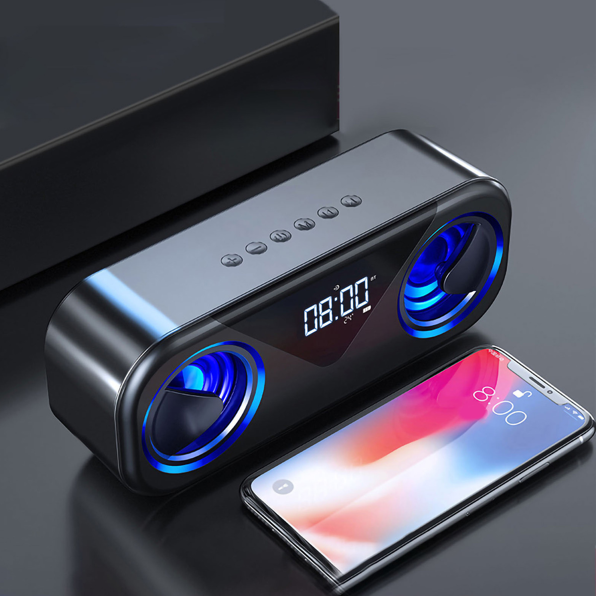 Ein schwarzer Bluetooth-Lautsprecher mit blauen Lichtern und einem digitalen Display, daneben ein Smartphone.