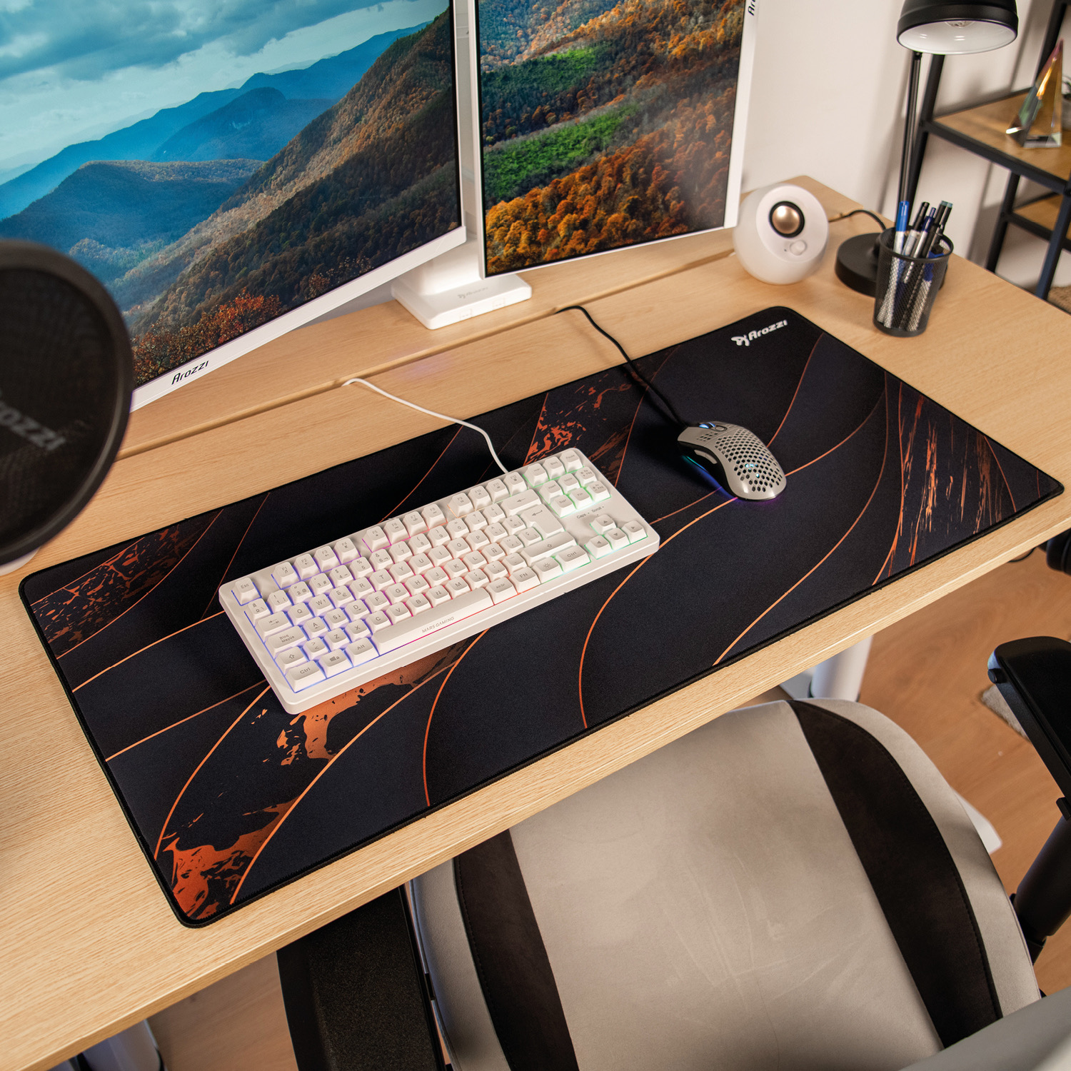 Ein Schreibtisch mit zwei Monitoren, Tastatur, Maus und Mauspad.