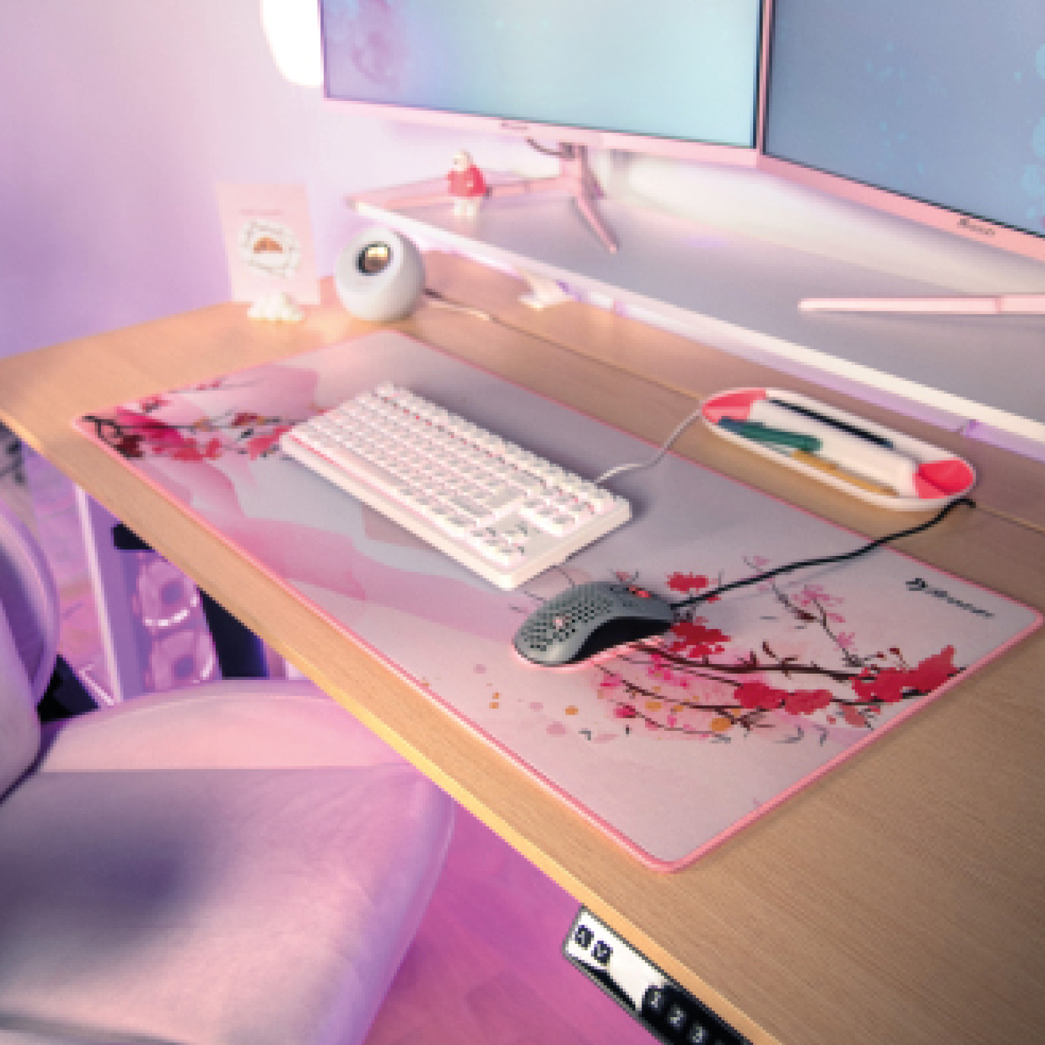 Ein Schreibtisch mit Tastatur, Maus und Computermonitoren, dekoriert mit Kirschblüten.