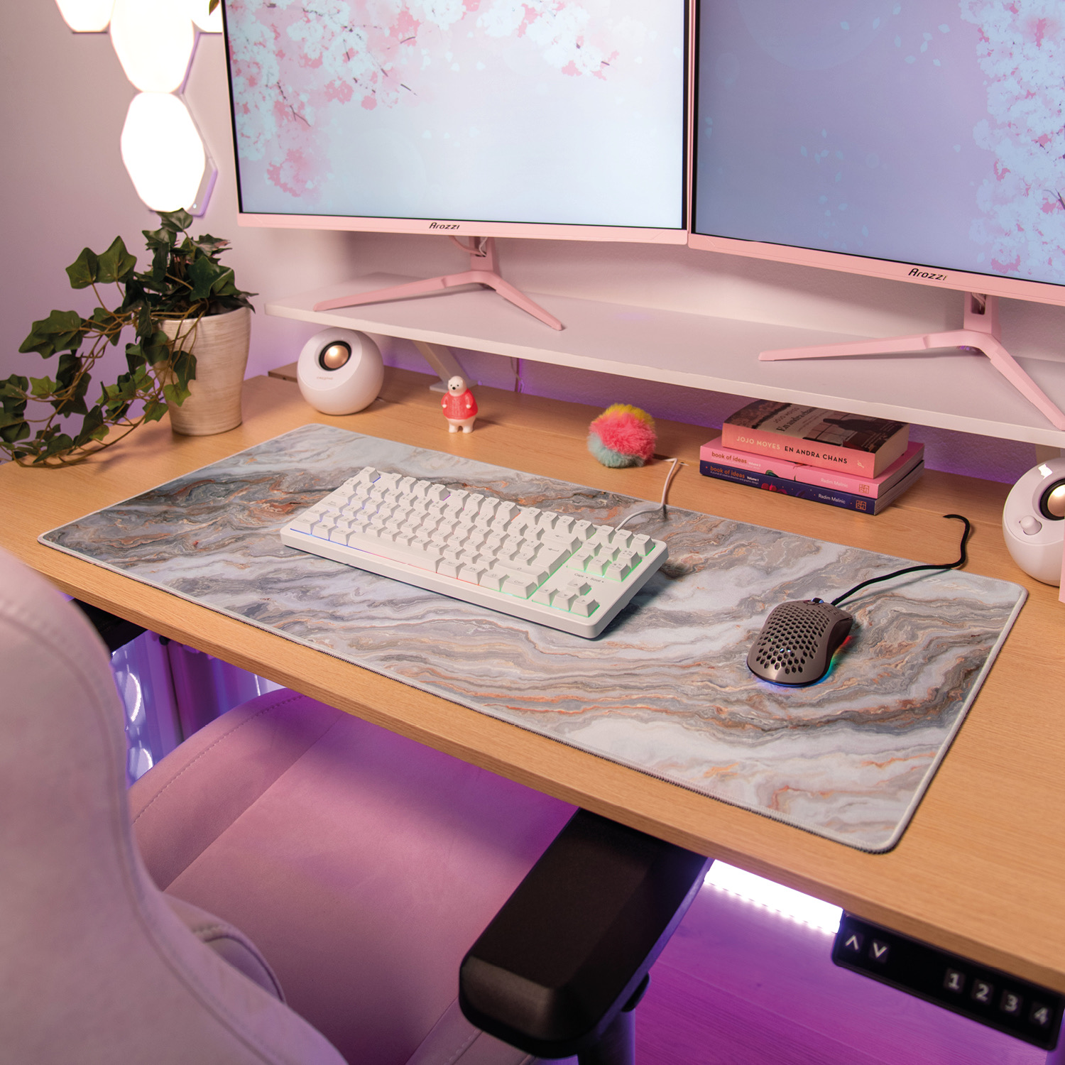 Ein pinker Gaming-Stuhl, Schreibtisch mit Marmor-Mauspad, Tastatur und Dual-Monitore.