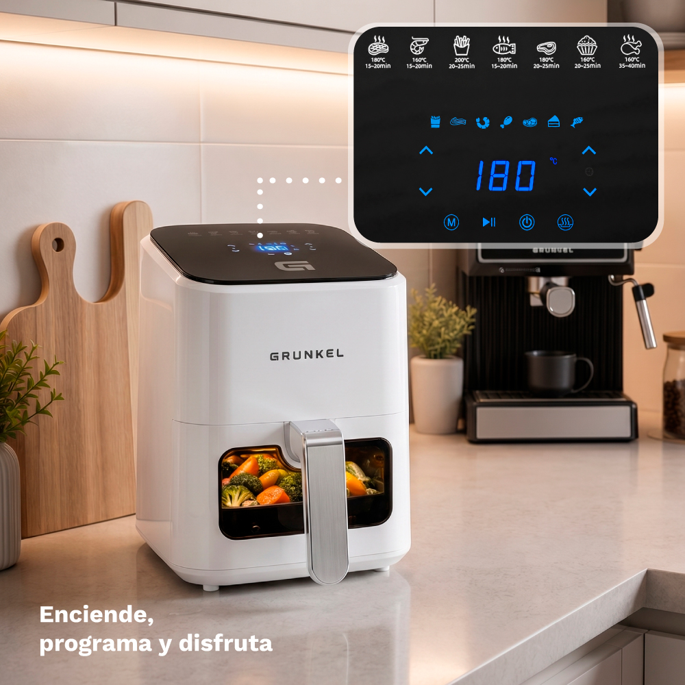 Friggitrice ad aria bianca con verdure nel cassetto, macchina da caffè accanto.