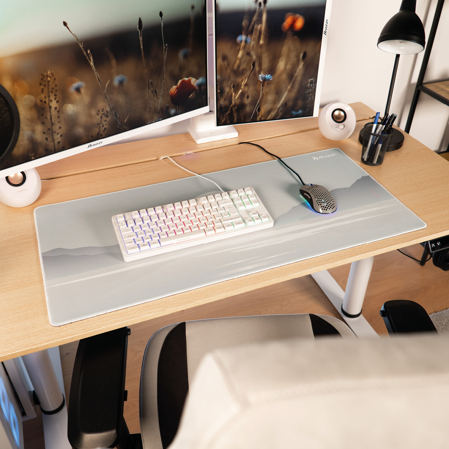 Ein Schreibtisch mit zwei Monitoren, Tastatur, Maus und Lampe.