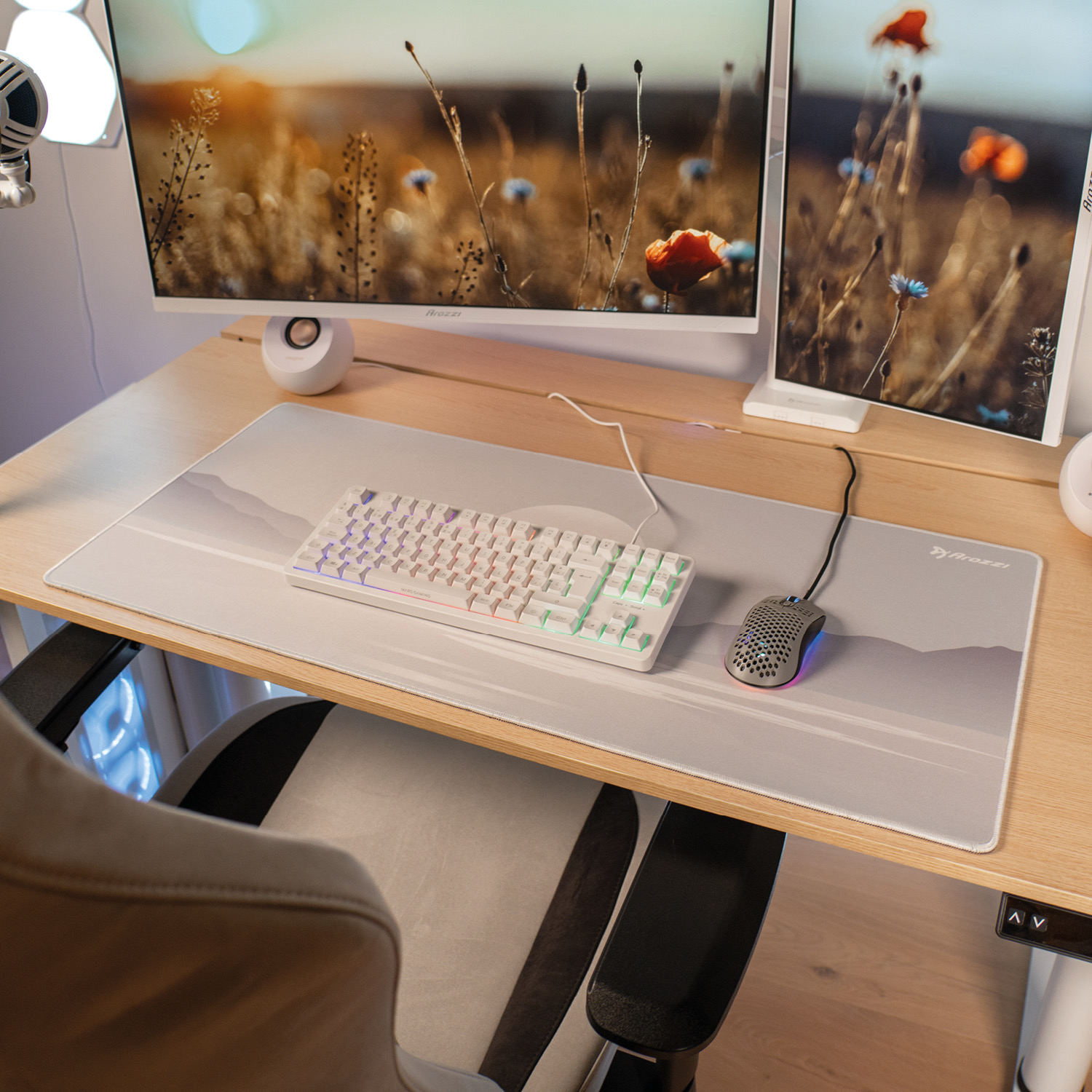 Ein Schreibtisch mit Tastatur, Maus und zwei Monitoren, die Blumen zeigen.